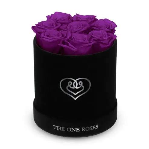 Suede Flat | Basic Black Box Purple Suede Flat | Basic Black Box Purple - Our Black-Suede Basic Box with The One Eternity Roses comes in a luxury suede hand crafted box. About 8 stems of The One long lasting (med size) preserved real roses.   Durability: approx. 1-3 years.   Product Dimension: 6″ × 6″ / 8 ROSES   Our roses, which are carefully sourced from the highest quality gardens in Ecuador, are made to represent the eternal yet ephemeral nature of Love itself. Our Roses are specially customized with essential oils to increase the fragrance.   Product Care: DO NOT Water the roses! AVOID direct exposure to sunlight. Keep the arrangement in a room-temperature environment. If dust collects after a few months, remove it lightly using a duster. DO NOT place anything onto the roses as they can crush and damage the roses. DO NOT remove the roses from the box; they are secure and happy there. DO NOT allow roses to have direct contact with light colored fabric or surfaces, as staining may occur. The lid is meant to stay on the side or bottom of the box. Be mindful when carrying the arrangement: it's a very delicate product!
