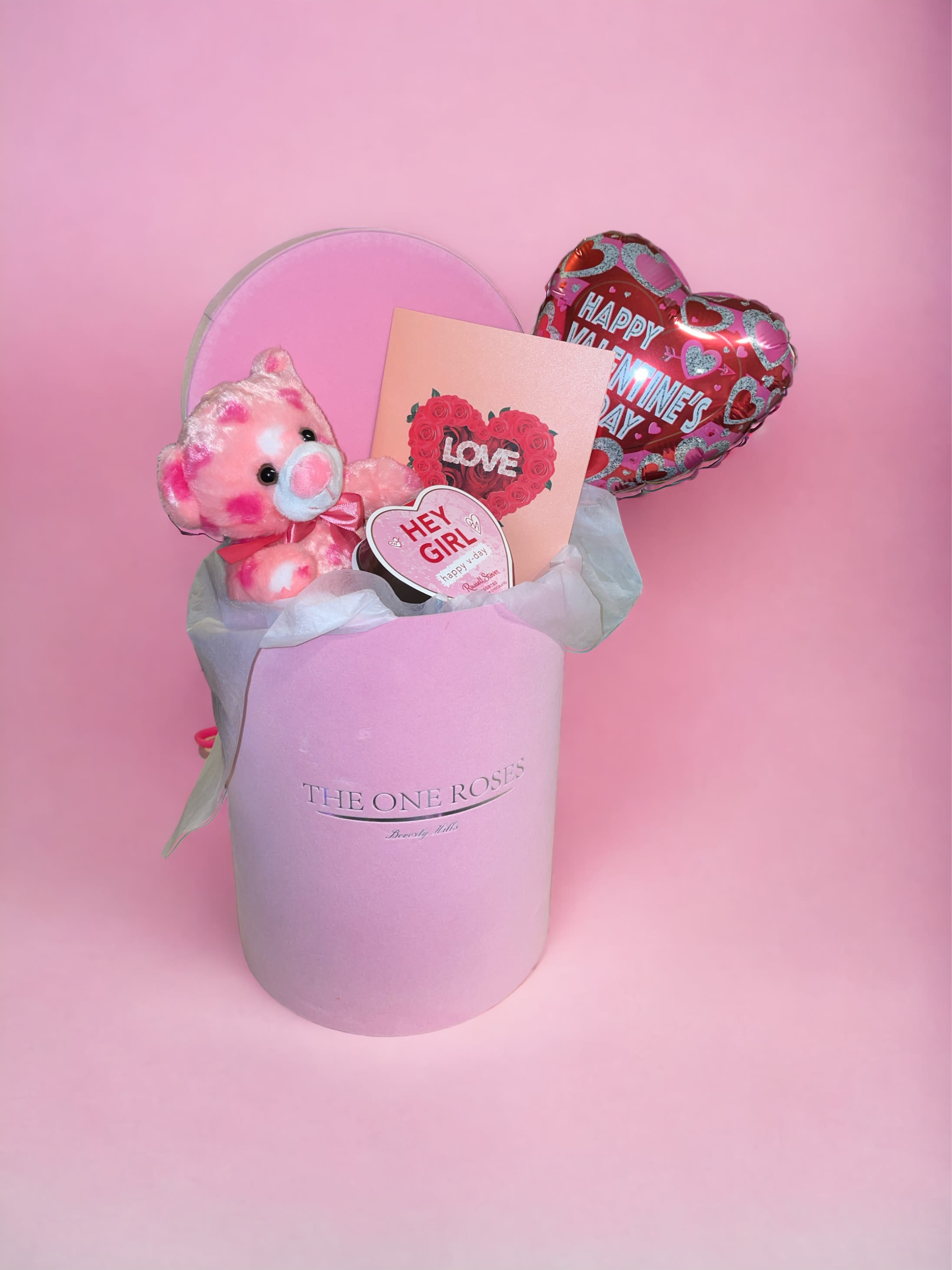 Valentines Day Plush Gift Box - Teddy bear plush comes inside our Pink Suede Round Gift Box with a small box of chocolate, a 3D Valentine’s Day pop up card, a plush, and a balloon stick on a bed of luxurious white tissue. Perfect gift for Valentine’s Day!  