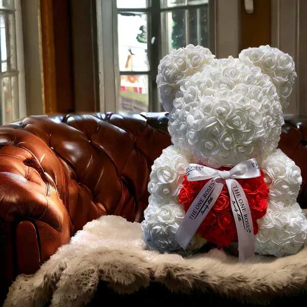 White Red Heart Rose Bear White Red Heart Rose Bear - Give someone special our gorgeous The One Rose Bear handmade of roses that last forever.  The perfect gift that will look great as a decoration piece in your loved one's home or office. Designed with synthetic roses in beautiful colors, this handmade Rose Bear lasts a lifetime with no care needed!  The best gift for Birthdays, Christmas, Valentine's Day, Mother's Day, Anniversaries, Baby Showers, Gender Reveal, Proposals, Weddings, or any occasion that warrants such a unique and precious gift.  Our authentic Rose Bear comes with our The One Roses Satin Bow and is available only in medium (14 inch) size.  What's Included?  The One Roses Signature Gift Box The One Roses Satin Ribbon The One Roses Rose Bear of your choice of color