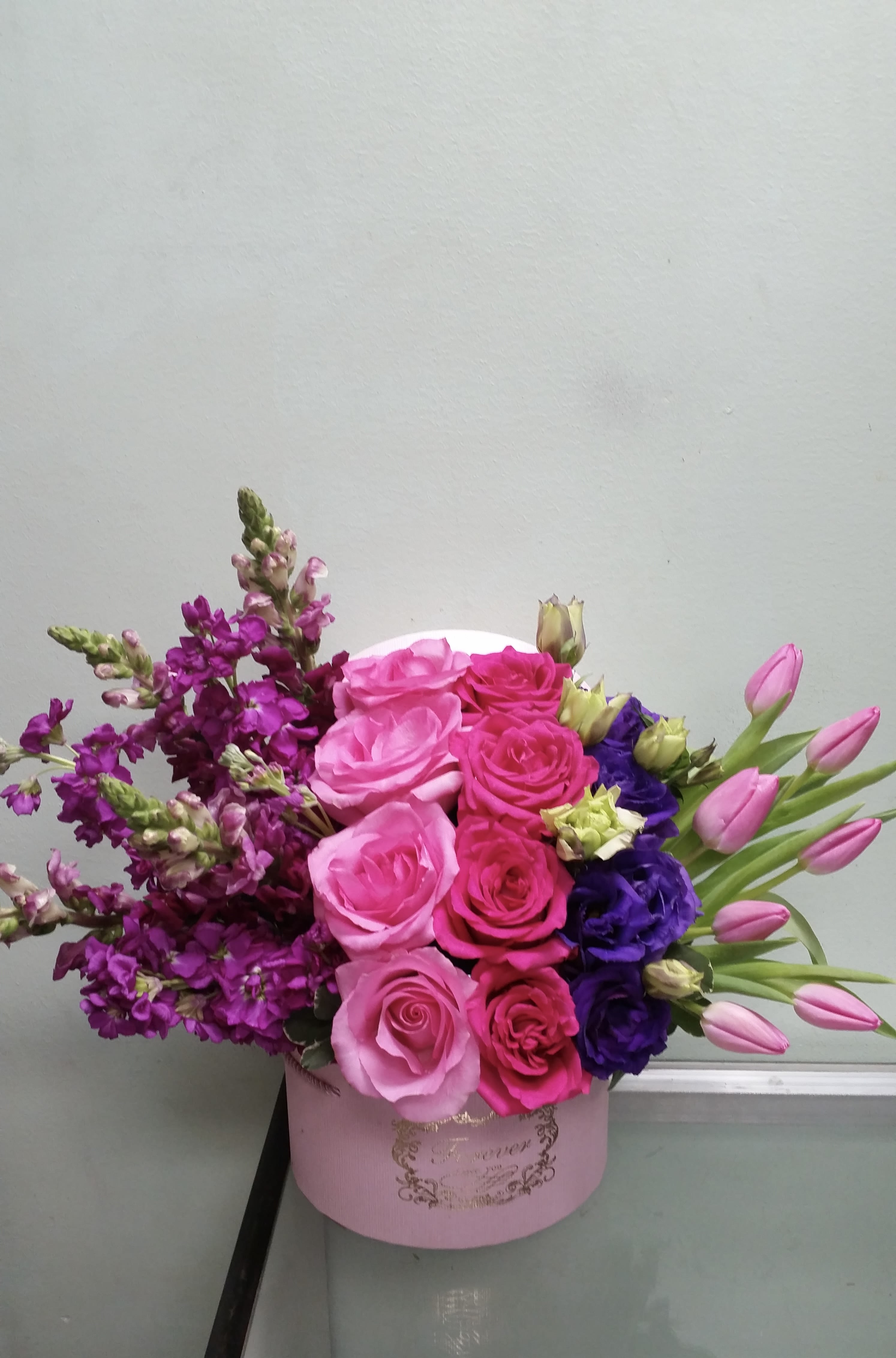 Pink Harmony Pink Harmony - Box arrangement with roses, snapdragons, tulips, stock, and lisianthus.