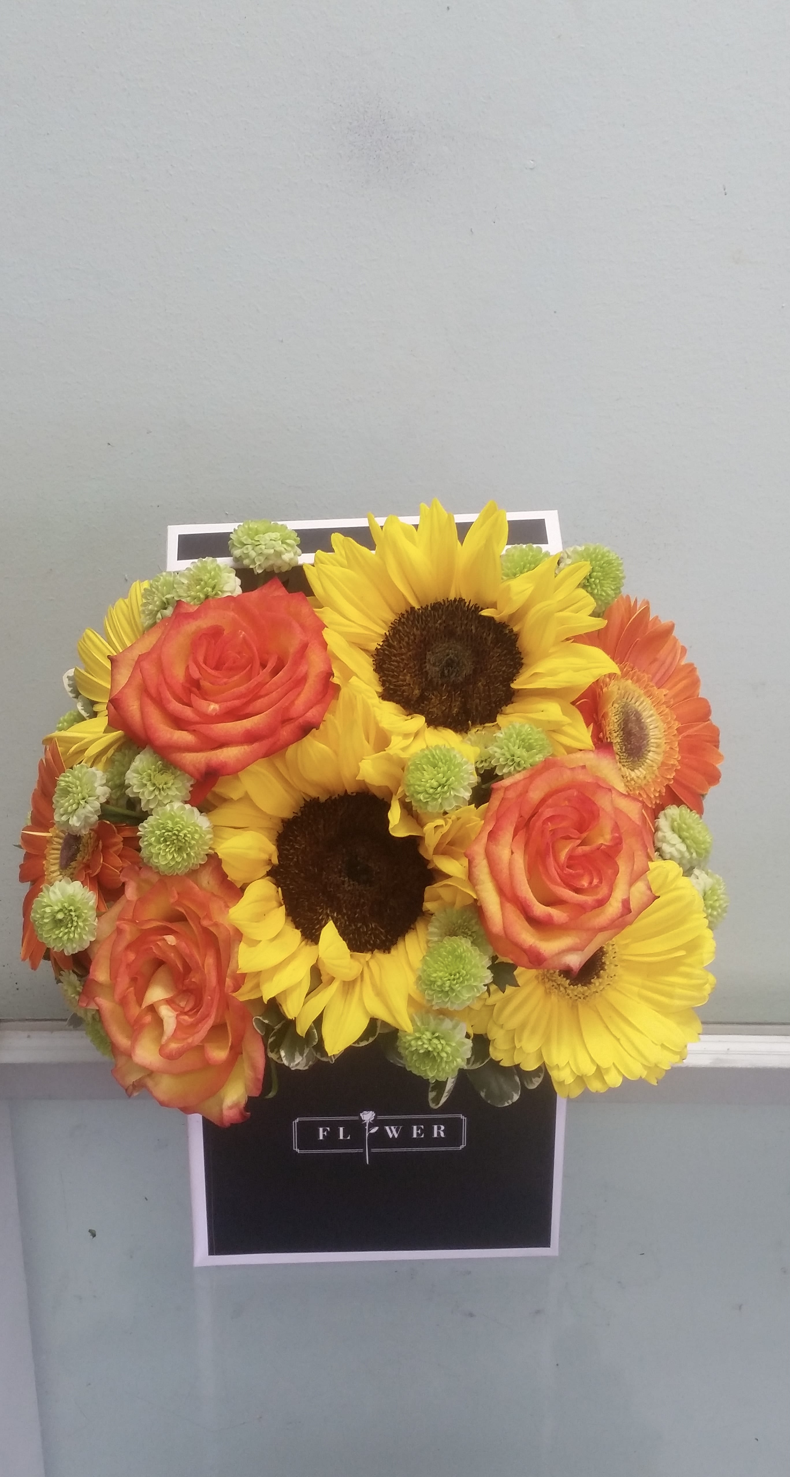 Sunshine Glow  - Box arrangement with sunflowers, roses, gerbera daisies, and button daisies. 
