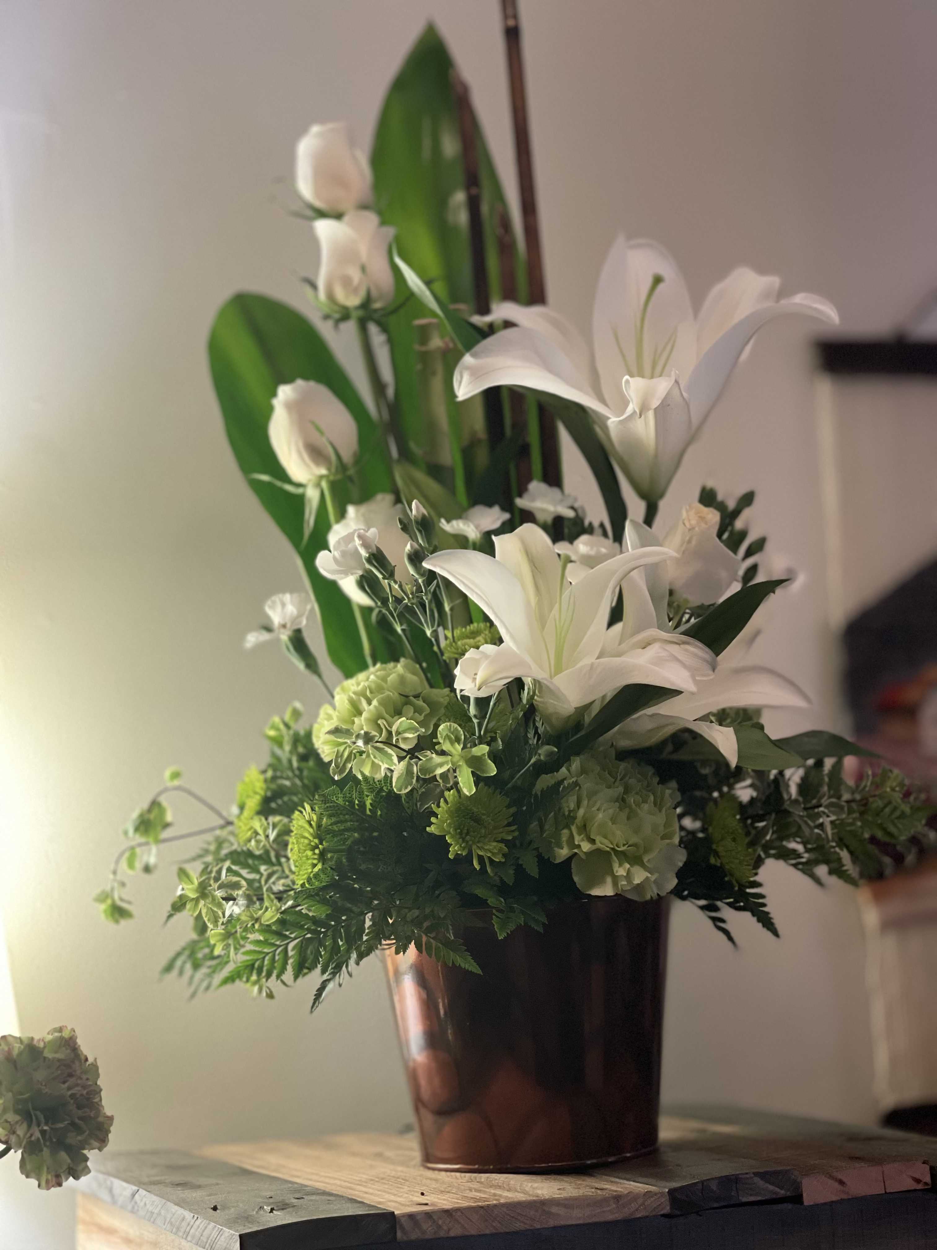 WHITE HALO - WHITE FLOWERS AND TOUCH OF GREEN CARNATIONS OR ANY TOUCHOF SEASONAL FLOWERS.   LYLIES,ROSES AND CARNATIONS 