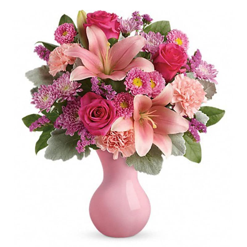 LUSH BLUSH BOUQUET - Inspired by the beautiful blush of happy cheeks, this fabulous mix of roses, lilies and carnations, presented in a pink keepsake vase, will make them feel like the extra special person they are!  This pleasingly pink bouquet includes pink roses, pink asiatic lilies, pink carnations, pink matsumoto asters, lavender cushion spray chrysanthemums, pink sinuata statice, dusty miller and lemon leaf. Delivered in a pink plastic vase.  Approximately 15&quot; W x 17&quot; H  Orientation: One-Sided      As Shown : TEV45-2A
