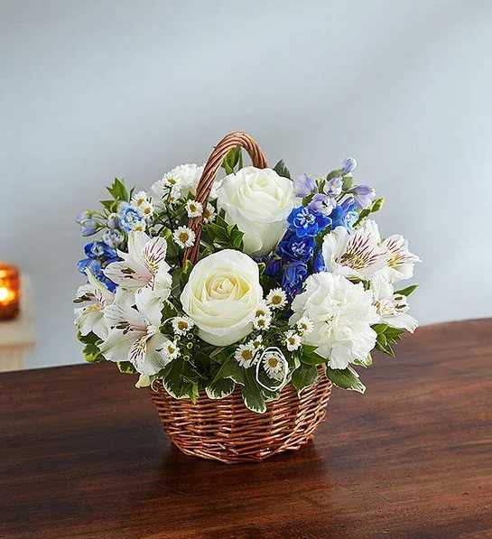 Peace, Prayers &amp; Blessings Blue &amp; White -  Artistically designed inside a  basket, our arrangement of heavenly blue delphinium and white roses is a touching way to convey your sincerest blessings.