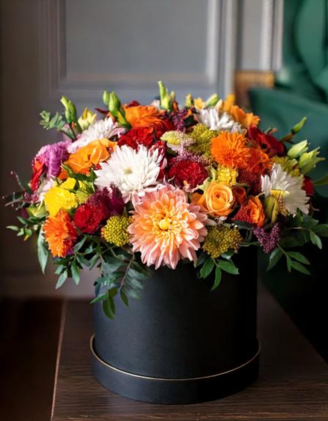 Flower Power - This floral arrangement showcases a vibrant mix of dahlias, chrysanthemums, and roses, presented in a black hatbox. A perfect gift for any occasion. Bring joy and beauty into any space with this exquisite bouquet, designed to impress and delight.