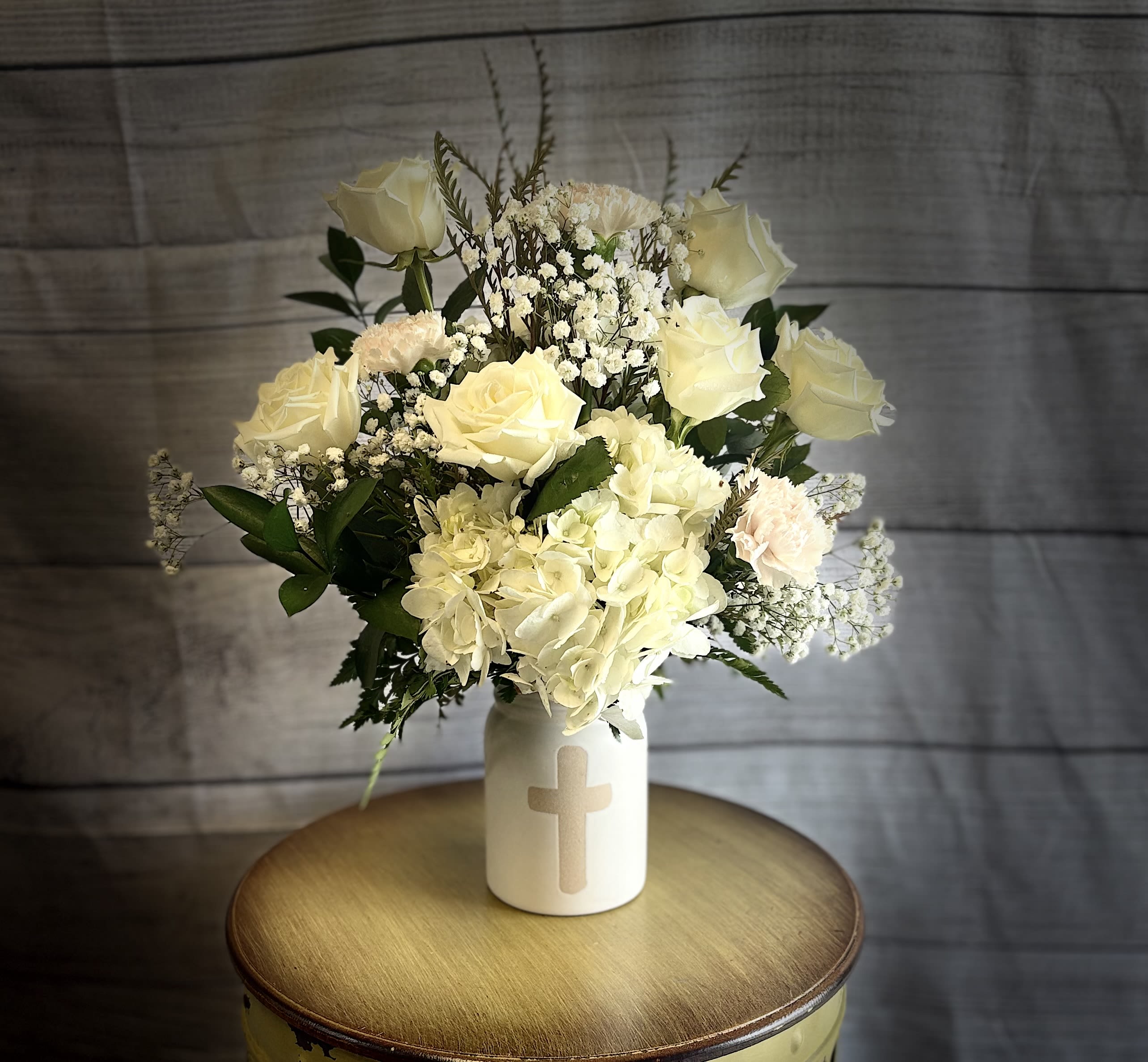 Faith Faith - Providing hope, courage, and resilience in times of sorrow Faith is a beautiful mixture of all white seasonal flowers in a keepsake container. Faith is a light that leads through the darkest times and has the power to bring healing and joy!