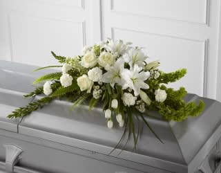 Eternal Peace Casket Spray - May his soul be blessed with eternal peace in the hands of our Lord. Send this elegant all white casket spray to sympathize to a grieving family.  All White Roses, Carnations, Tulips, Lilies, Snapdragons, Monte Casino, Larkspur, Bell of Ireland, Lily Grass Blades, Sword Fern Fronds, Myrtle &amp; Pittosporum Stems  Approximately   32&quot; W x 24&quot; D
