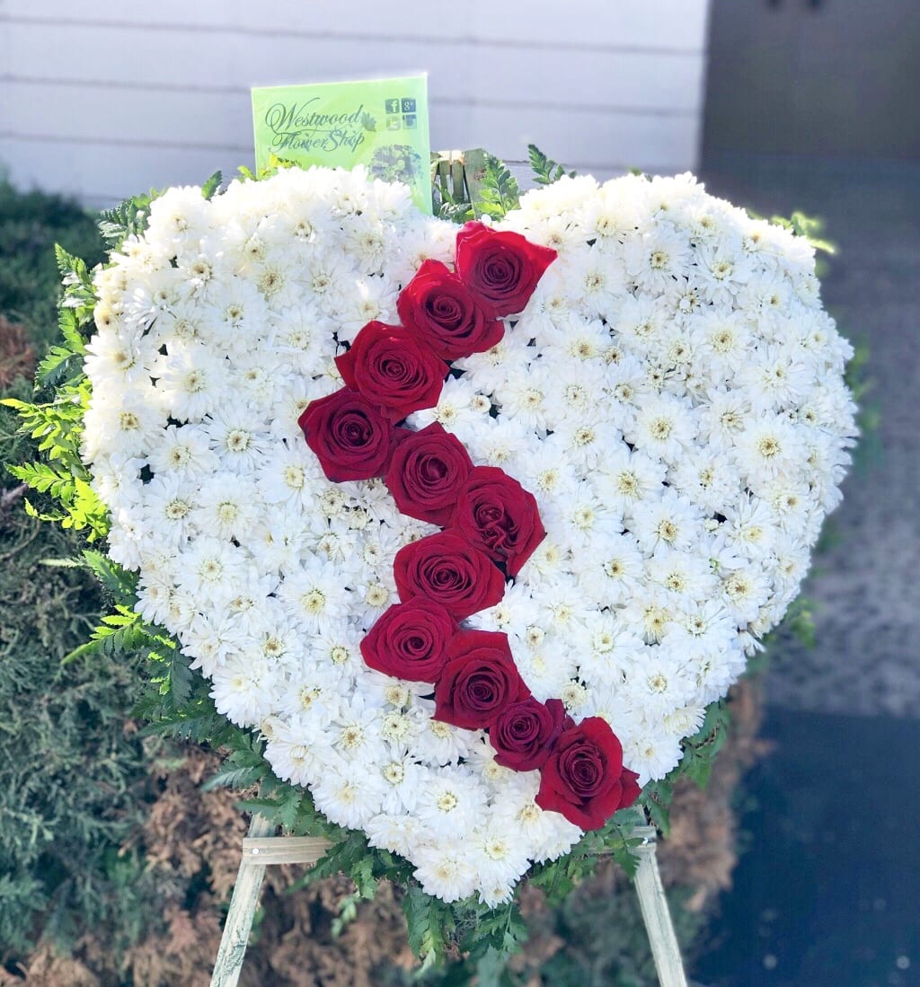 Broken Hearted Standing Spray Broken Hearted Standing Spray - For a departing loved one who dearly deserves all the love in the world until after life. Order this one of a kind solid heart standing spray filled with white cushion pompom and accentuated with premium bloomed dozen Ecuadorian roses artistically designed to catch the eye. Approximately 22" D