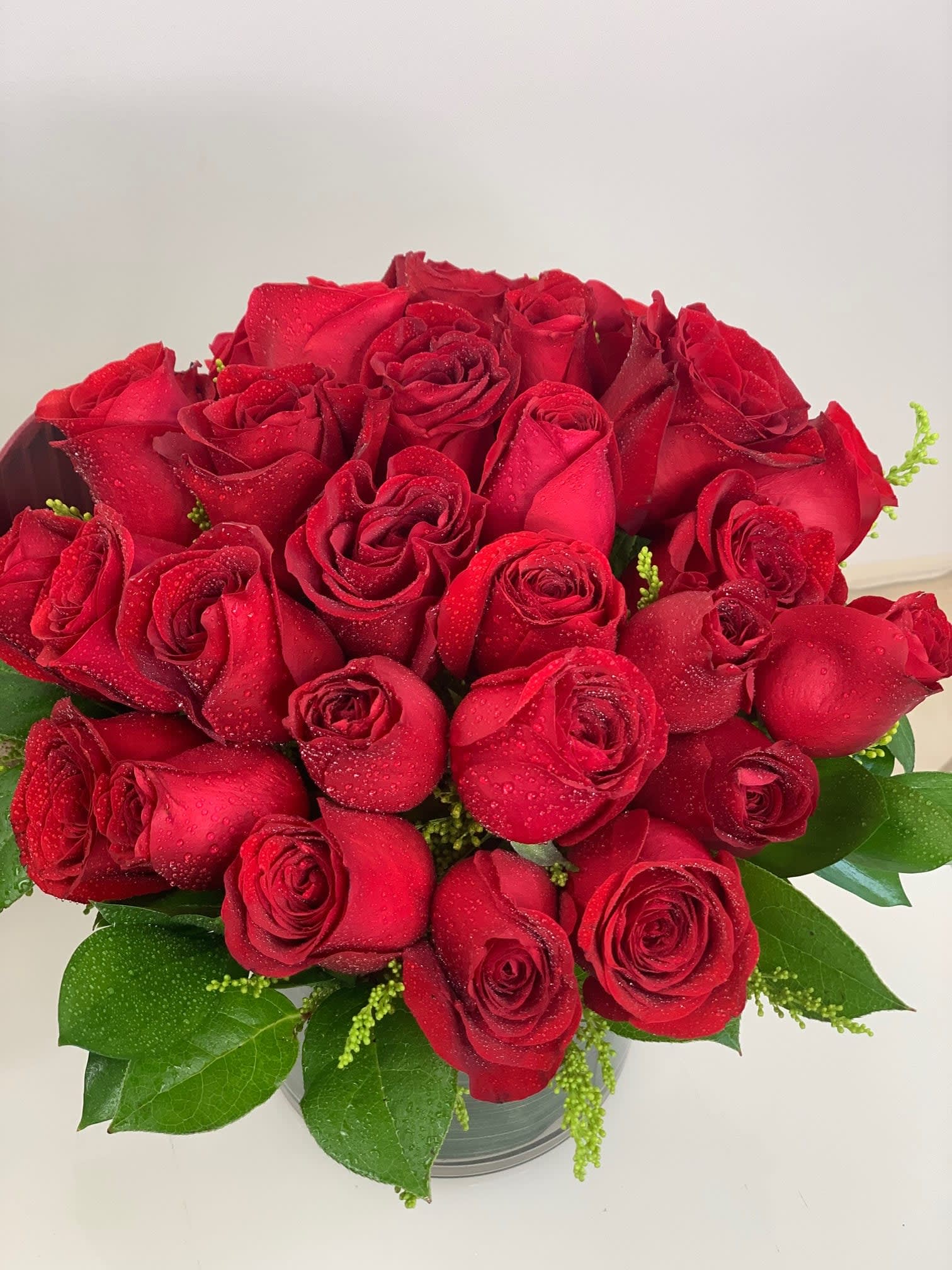 Premium Red Roses Velvet - This arrangement is full of quality red roses and very classy looking. Round shape in a cylinder vase. Next day delivery.
