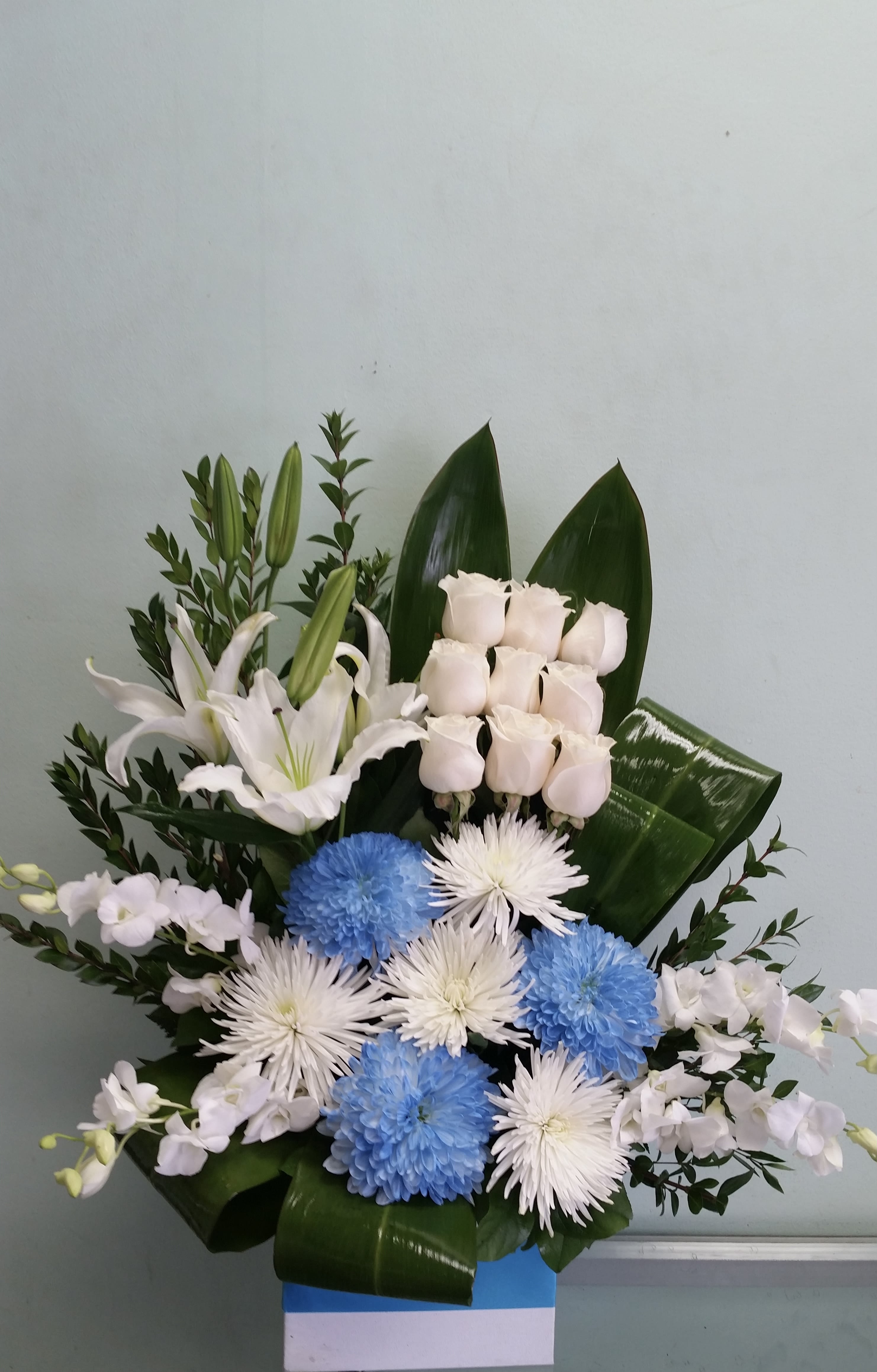 New Beginnings New Beginnings - Box arrangement with mums, roses, lilies, and orchids
