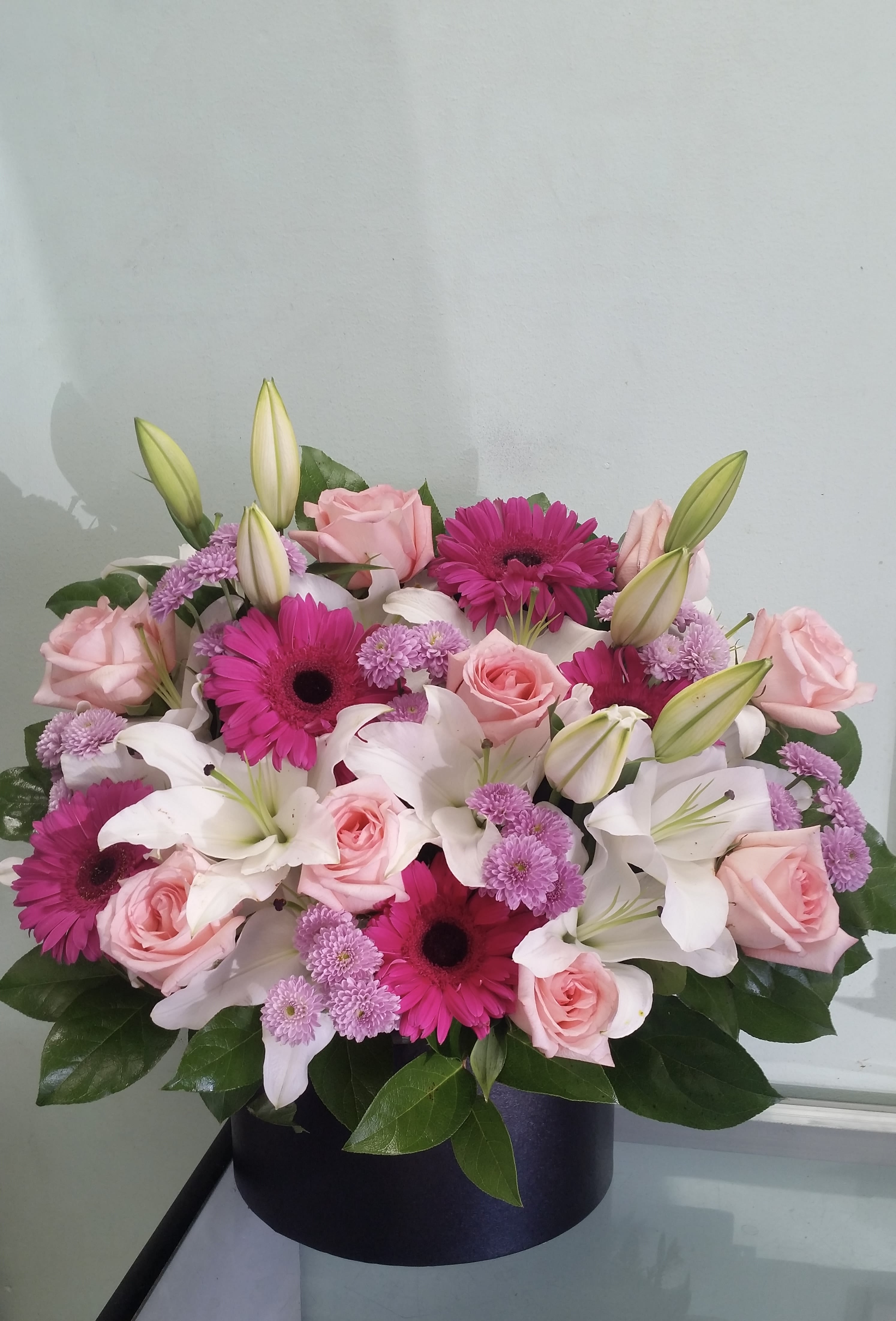 Joy of Spring Joy of Spring - Box arrangement with roses, lilies, gerbera daisies, and button daisies.