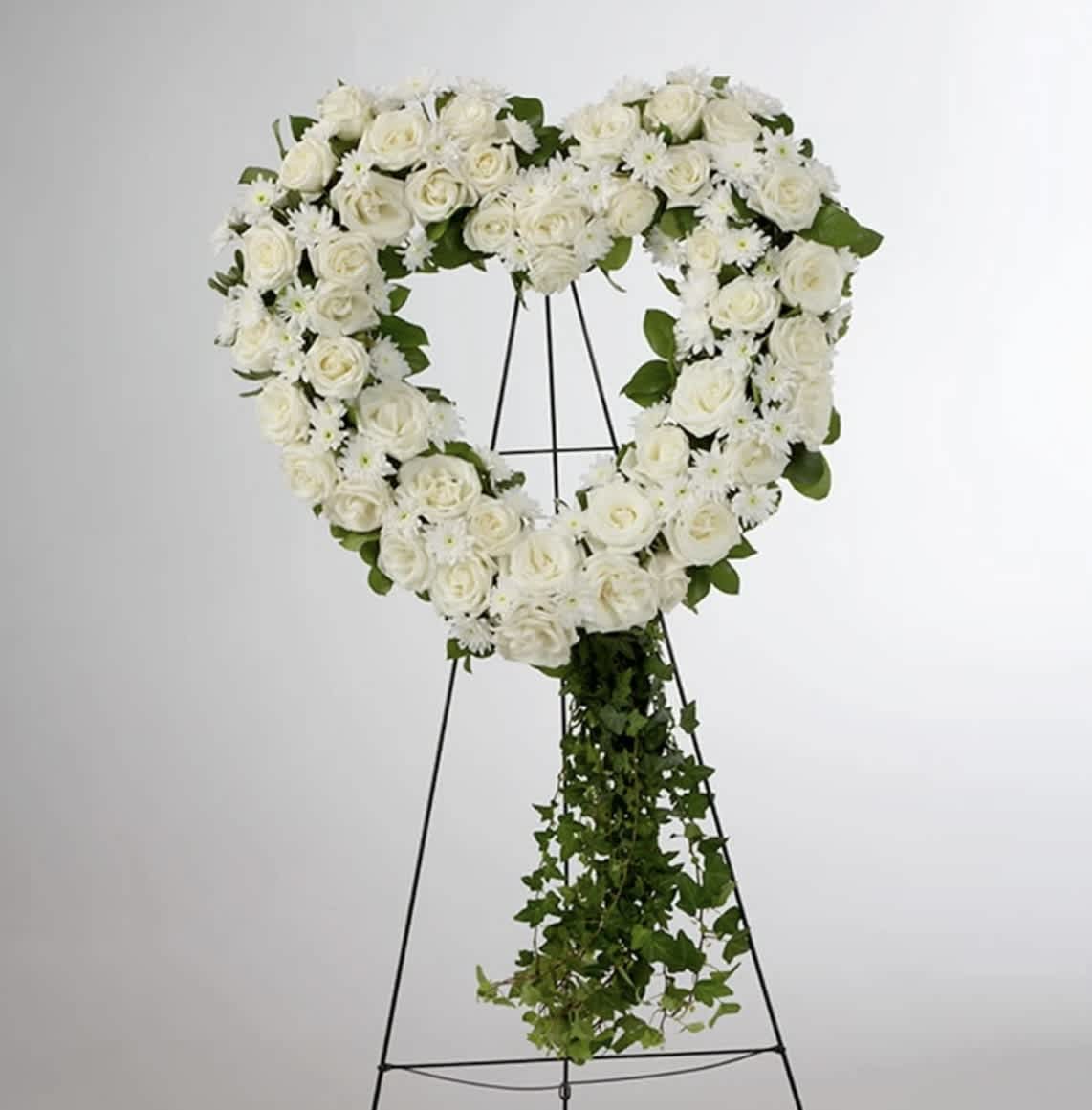Love in our Hearts by BloomNation™ Love in our Hearts by BloomNation™ - An all white tribute, this heart shaped easel shows your everlasting love. Featuring a variety of white flowers and greenery, this heart with a trail of ivy compliments the beauty of life.