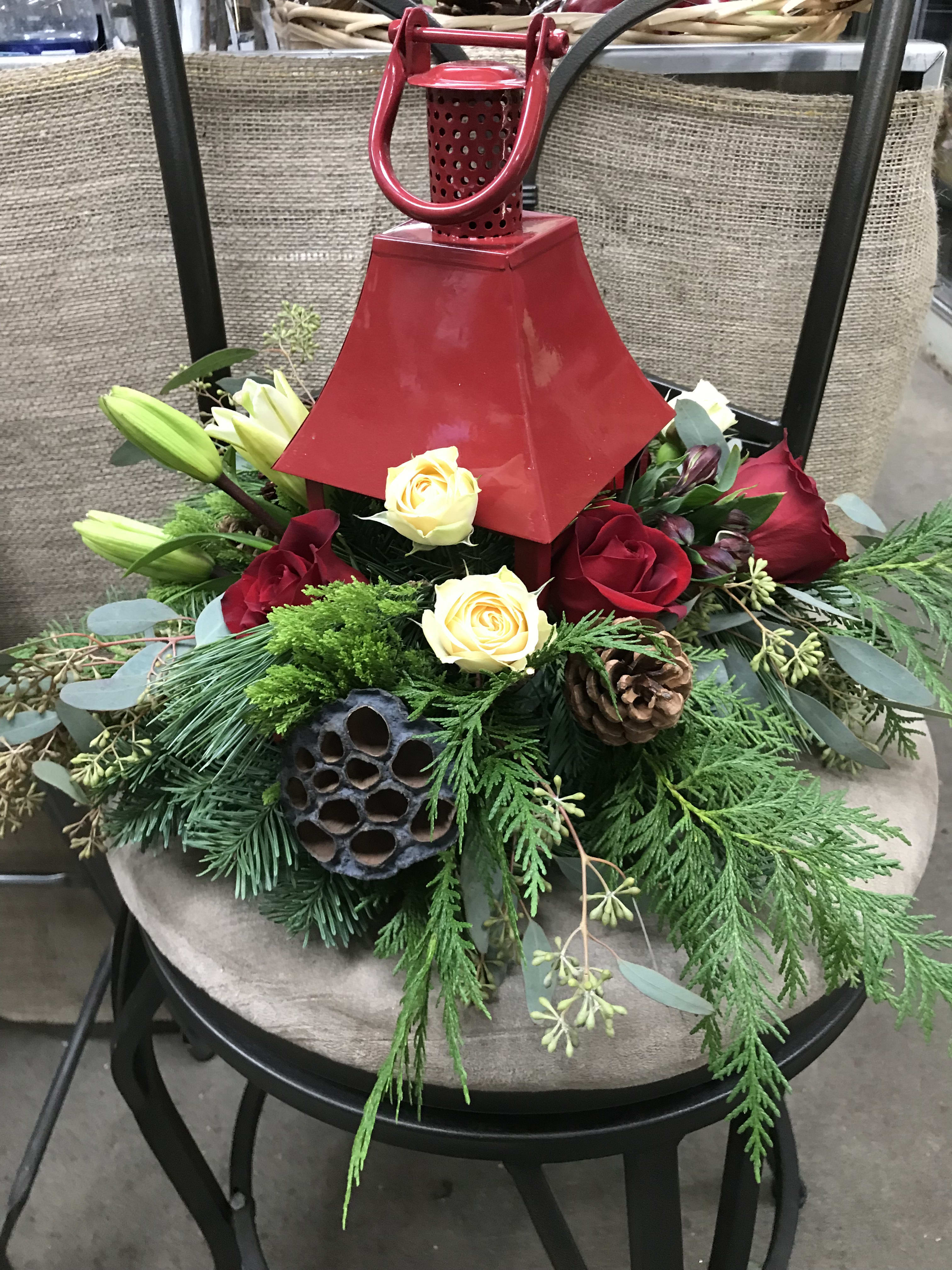 Red Lantern - A red lantern with a white candle surrounded by fragrant winter greens and seasonal flowers, can be used as a centerpiece or on a side table, makes a great gift as it can be used as a great feature after the florals are removed.