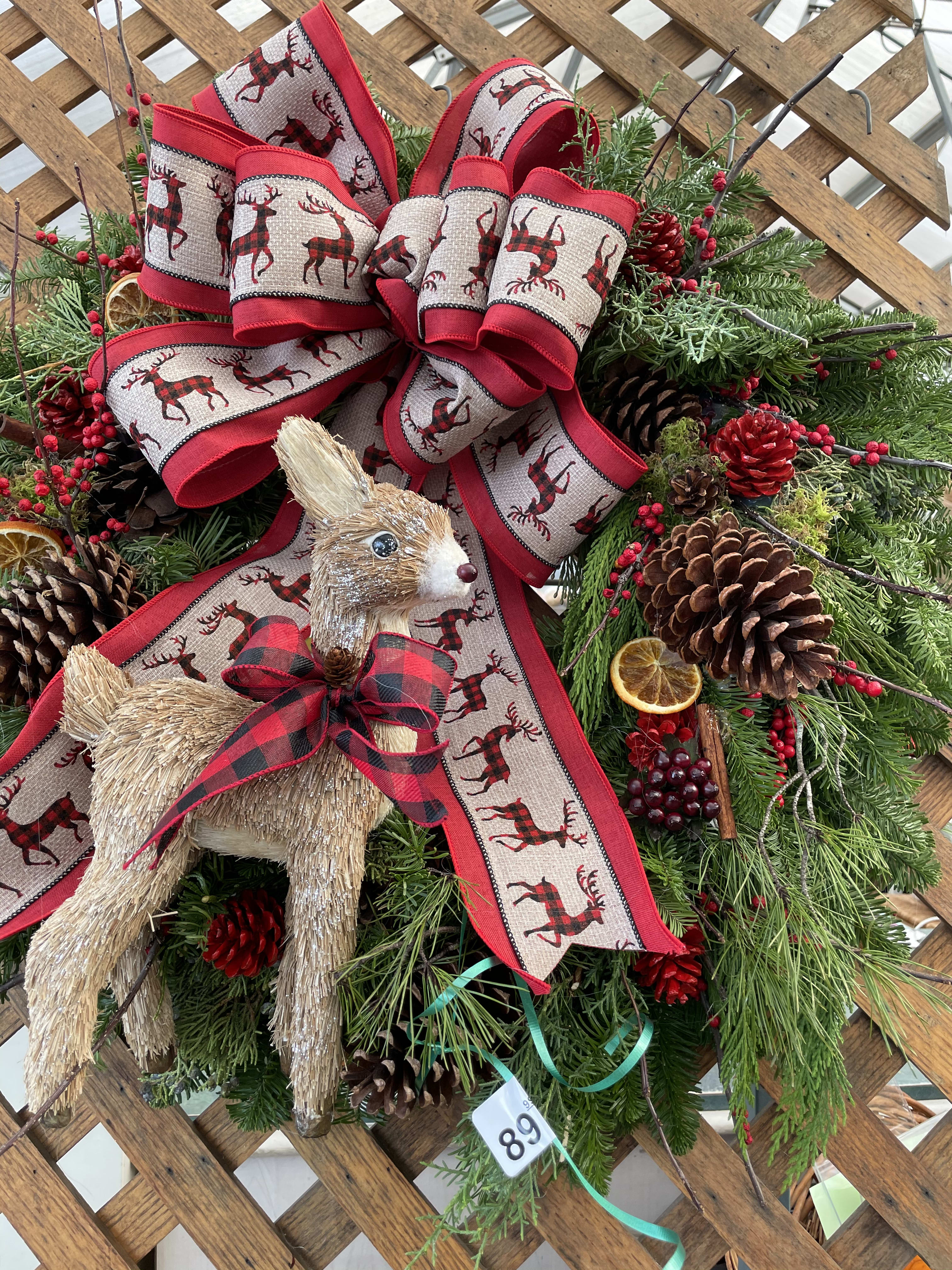 Seasons Greeting Wreath - A beautifully designed Christmas wreath, fresh fragrant greens, beautiful ribbons centered with a cute deer. Perfect for a special room or door. All wreaths are a little different from each other but will always reflect the theme.