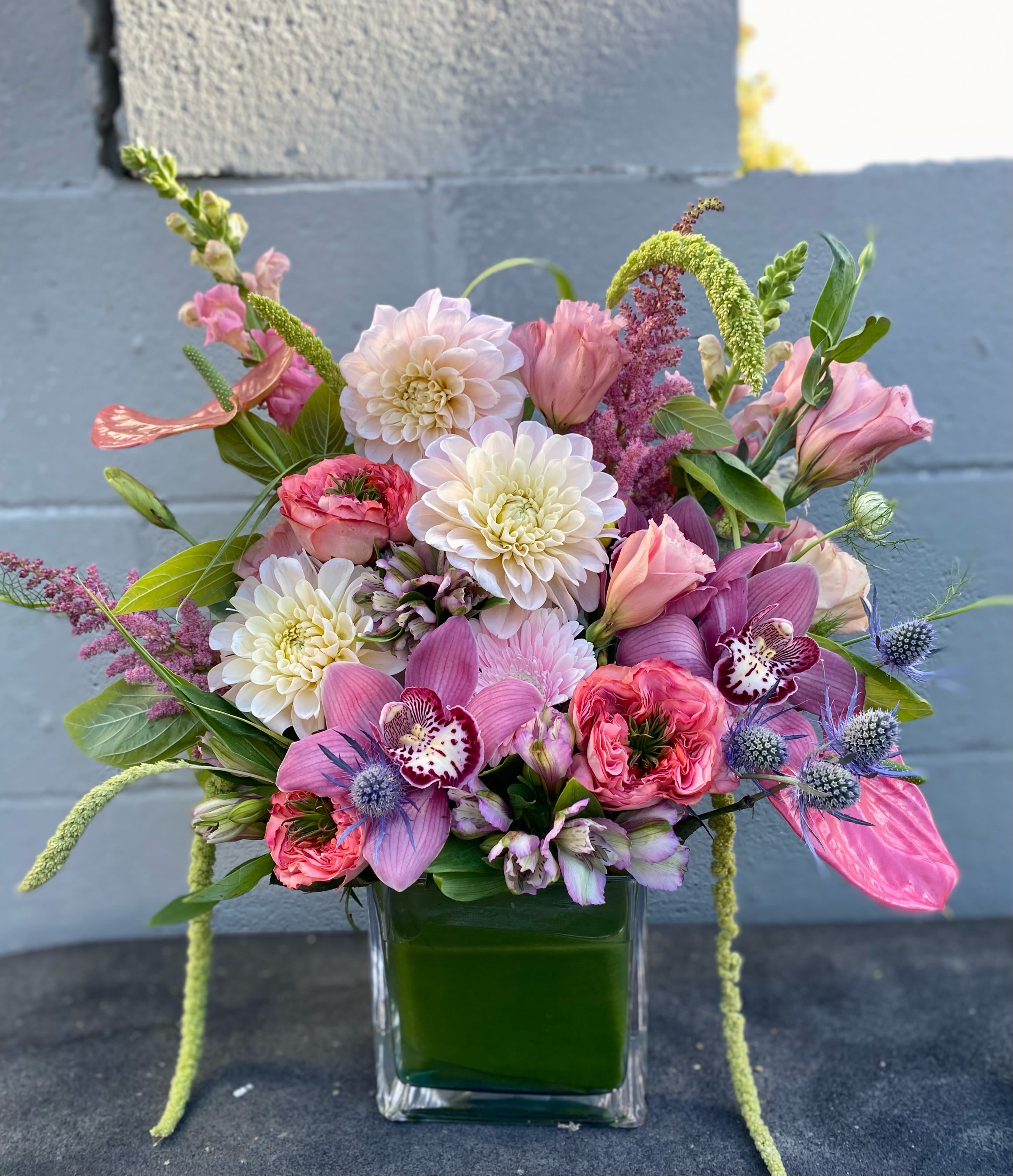 Everlasting Sparkle - This arrangement includes dahlias, lisianthus, cymbidium orchids, gerberas,, alstroemerias, green foliage, all beautifully assemble in glass vase. 