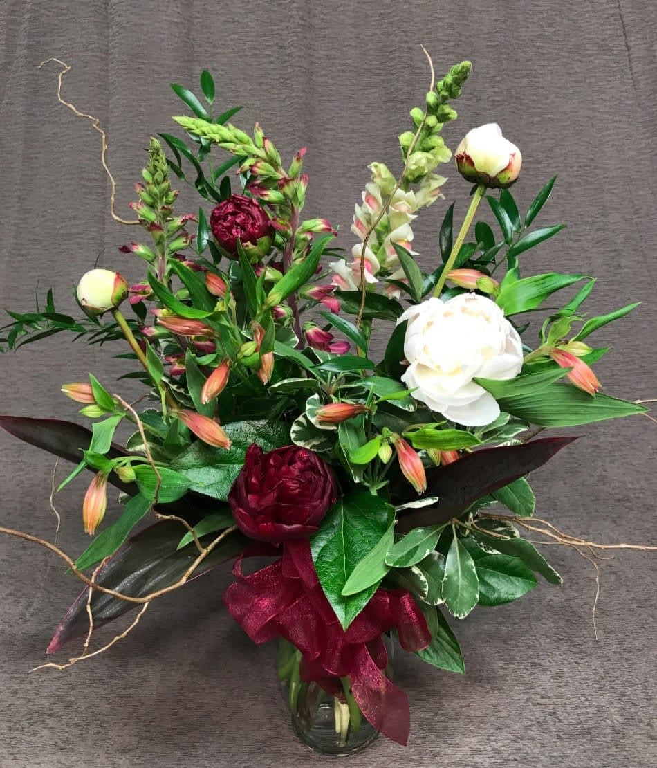 Elegant Peonies with Willow Branches - Peonies are available in short bursts throughout the year. Be sure to order these in advance!! We love them as many people do! Peonies come in a few shades and colors may vary. Be sure to provide any color requests and we will do our best but may need to substitute color.  Includes the curly willow branches or similar branch, in an elegant arrangement with accent flowers and foliage in a vase with bow.