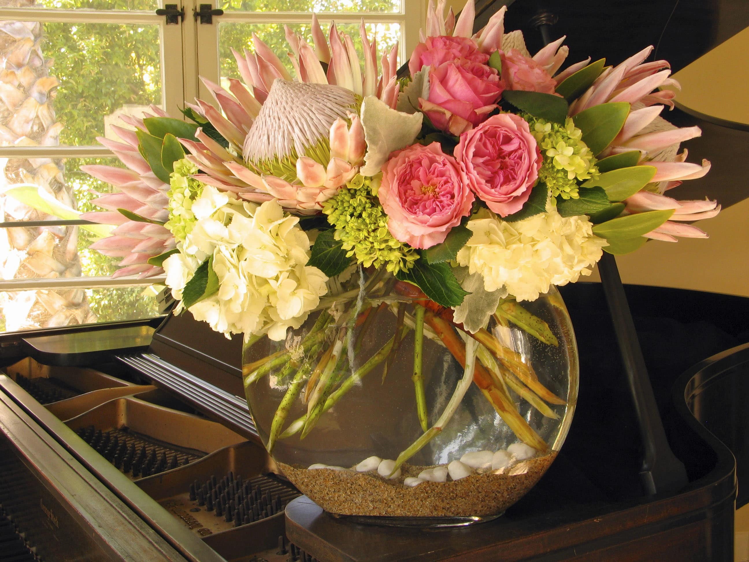179 Exotic fish eye - Exotic Floral Arrangement in Oval Fish Eye Vase from T'sul Custom Floral Design in Newport Beach, CA  Transform your decor with our stunning exotic floral arrangement, beautifully presented in an elegant oval fish eye vase, exclusively from T'sul Custom Floral Design in Newport Beach, CA. This eye-catching arrangement features a curated selection of fresh exotic flowers sourced from today’s flower market, ensuring a vibrant and unique display that captivates the senses.  Perfect for accenting your home, office, or special events, our oval fish eye vase arrangement showcases a delightful variety of colors and textures that are sure to impress. Each flower is carefully selected for its beauty and freshness, creating a luxurious and sophisticated centerpiece that enhances any space.  Key Features:  Unique oval fish eye vase filled with a variety of fresh exotic flowers Perfect for home decor, corporate settings, or special occasions Sourced from today’s flower market for the highest quality and freshness Offers a stunning visual impact with vibrant colors and diverse textures Bring a touch of the extraordinary to your Newport Beach home or office with T'sul Custom Floral Design’s exotic floral arrangement in an oval fish eye vase. Order today to experience the beauty of fresh, exotic blooms delivered straight to your door!