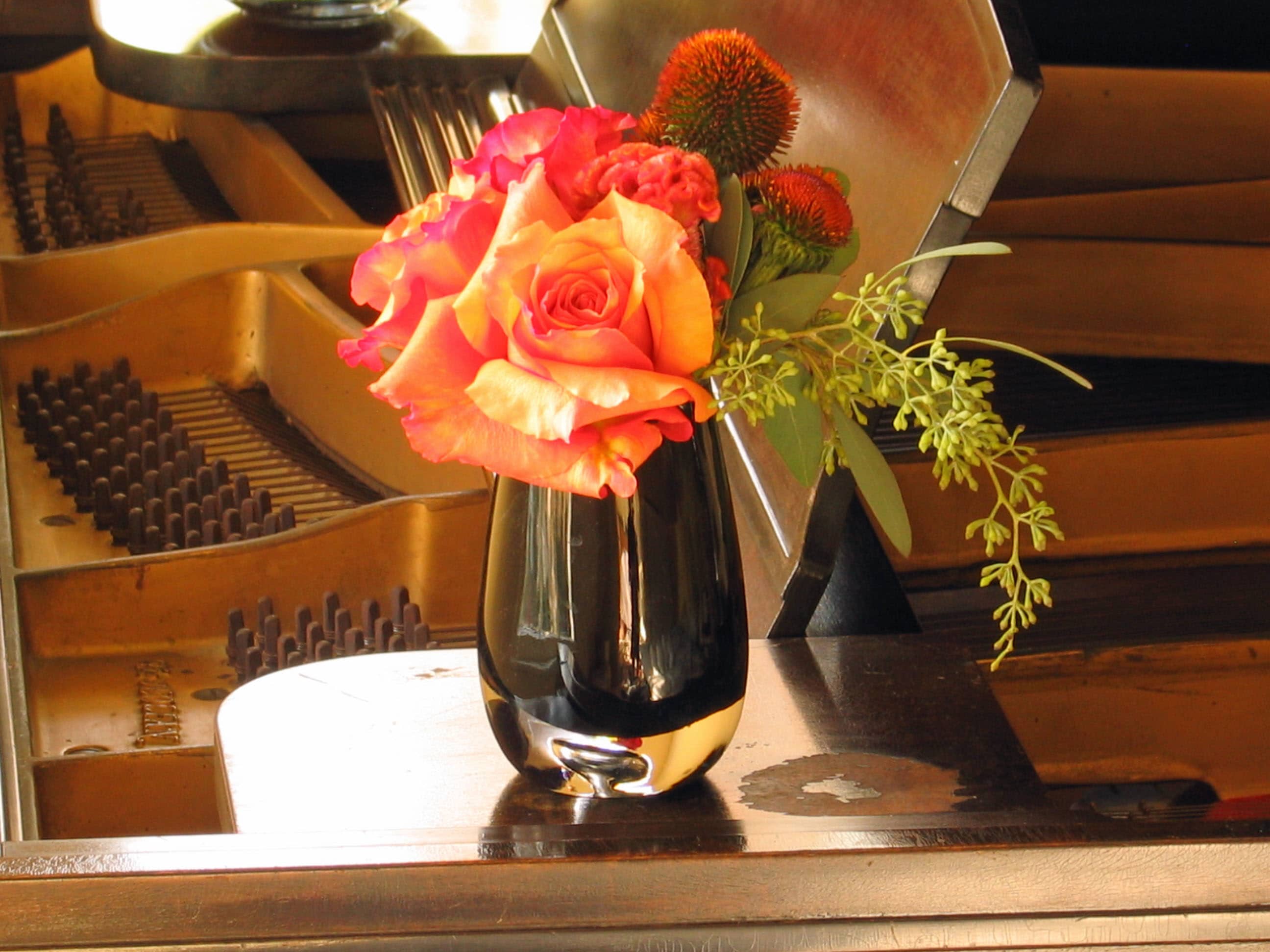 59 Rose Desktop &quot;Small is Beautiful&quot; - Elegant Rose Arrangement in Black Glass Tulip-Shaped Vase from T'sul Custom Floral Design in Newport Beach, CA   Enhance your desktop or vanity with our exquisite Rose Arrangement, beautifully paired with complementing flowers and lush greens, presented in a sleek black glass tulip-shaped vase from T'sul Custom Floral Design in Newport Beach, CA. This stunning floral display adds a touch of sophistication and charm to any space, making it the perfect accessory for your home or office.  Featuring premium-quality roses alongside a selection of fresh blooms and vibrant greenery, this elegant arrangement is thoughtfully designed to create a visually appealing centerpiece. Ideal for brightening up your workspace, dressing up your vanity, or gifting to a loved one, this arrangement brings beauty and freshness to any setting.  Key Features:  Beautifully arranged roses complemented by fresh flowers and lush greens Stylish black glass tulip-shaped vase perfect for desktops or vanities Ideal for home decor, office settings, or as a thoughtful gift for any occasion Crafted with high-quality flowers for lasting beauty and fragrance Transform your Newport Beach space with T'sul Custom Floral Design’s stunning Rose Arrangement in a black glass tulip-shaped vase. Order today to enjoy the timeless elegance of fresh flowers in your daily life!