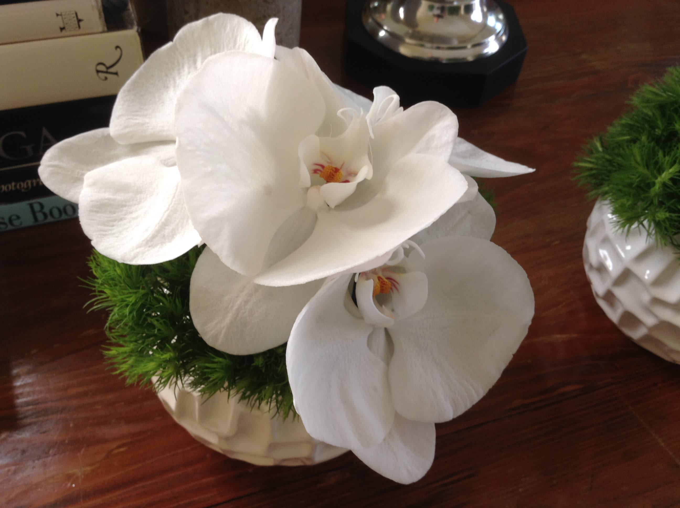 59 Zen Orchid &quot;Small is Beautiful&quot; -  Elegant Orchid Arrangement in Modern Ceramic Vessel from T'sul Custom Floral Design in Newport Beach, CA  Discover the timeless beauty of our exquisite orchid arrangements, featuring a selection of crisp, clean, pure white orchids or vibrant deep purple orchids, artfully presented in a contemporary white or black ceramic vessel. Available exclusively at T'sul Custom Floral Design in Newport Beach, CA, these stunning floral displays are perfect for enhancing your home or office decor.  Product Options:  As Shown: 5 blooms in a stylish ceramic vessel, ideal for desktop or tabletop displays. Deluxe Arrangement: 8-10 blooms for $89, offering a fuller, more luxurious look. Premium Arrangement: 9-12 blooms for $99, showcasing an abundance of beautiful orchids. These elegant orchid arrangements are often ordered in pairs, making them a perfect choice for special events, gifts, or as a sophisticated accent in your living space. Each arrangement is crafted with high-quality, fresh orchids to ensure lasting beauty and fragrance.  Choose from pure white or deep purple orchids for a stunning visual impact Presented in a modern white or black ceramic vessel to complement any decor style Ideal for home decor, corporate settings, or thoughtful gifts for any occasion Expertly arranged for maximum elegance and freshness Enhance your Newport Beach home or office with T'sul Custom Floral Design's elegant orchid arrangements. 