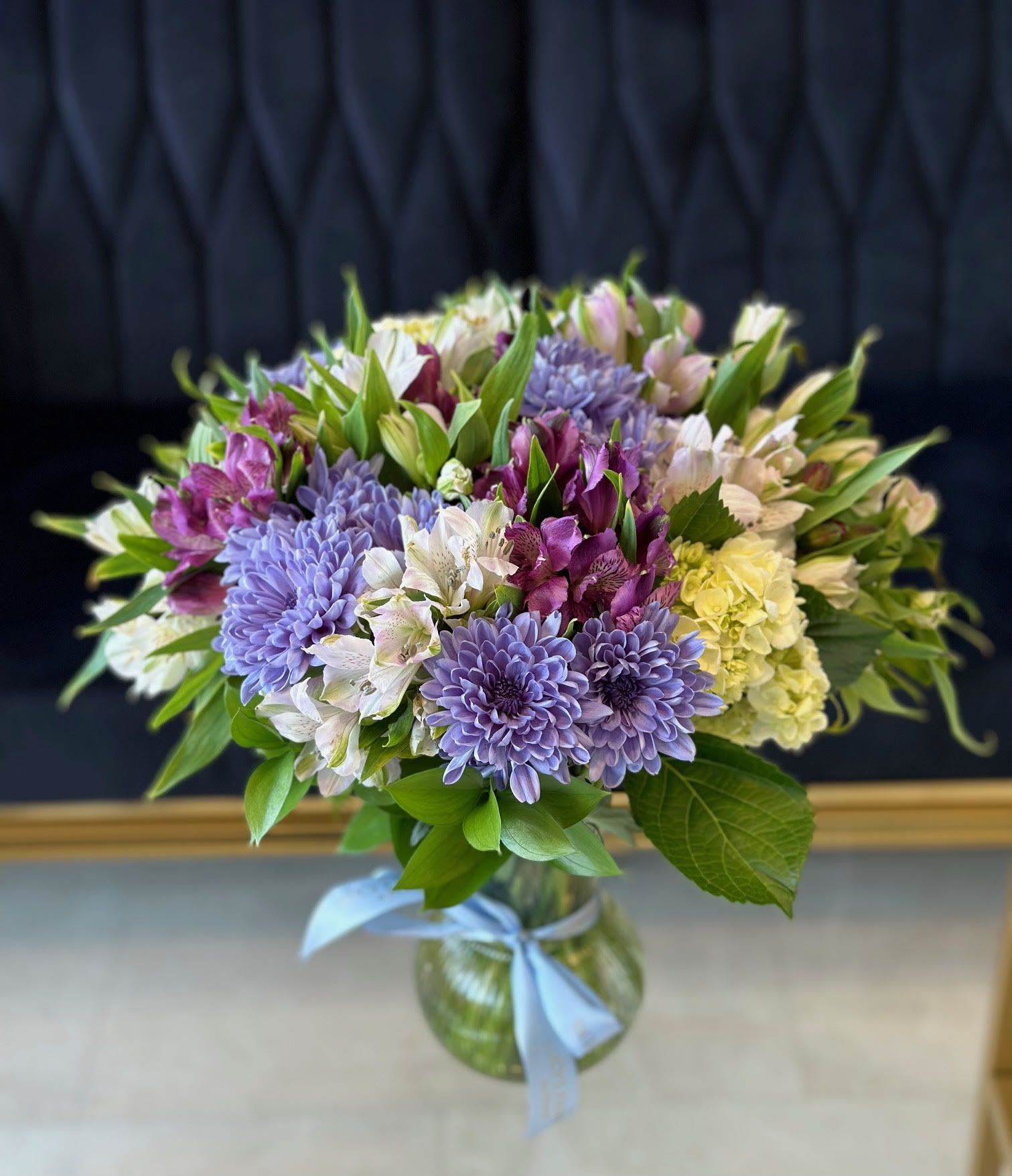 Joyful Garden - Pretty, distinctive and perfect for mother's day, birthday celebration, and those just because moments. This delicate arrangement of lavender daisies, hydrangeas and alstroemerias – assembled in a simple vase – will add an artistic touch to any occasion.  Arrangement Includes: -Glass Vase  -Fresh Cut Hydrangeas, daisies, alstroemerias, ruscus leaves -Custom Greeting Card -Care Instructions