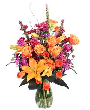 Wild Amber - This dazzling bouquet is perfect for any occasion! Sensational orange lilies, roses, and tulips are complemented with purple daisy poms, stock, and statice, making Wild Amber a striking mix. Add a pop of color to any occasion with this vibrant bouquet!