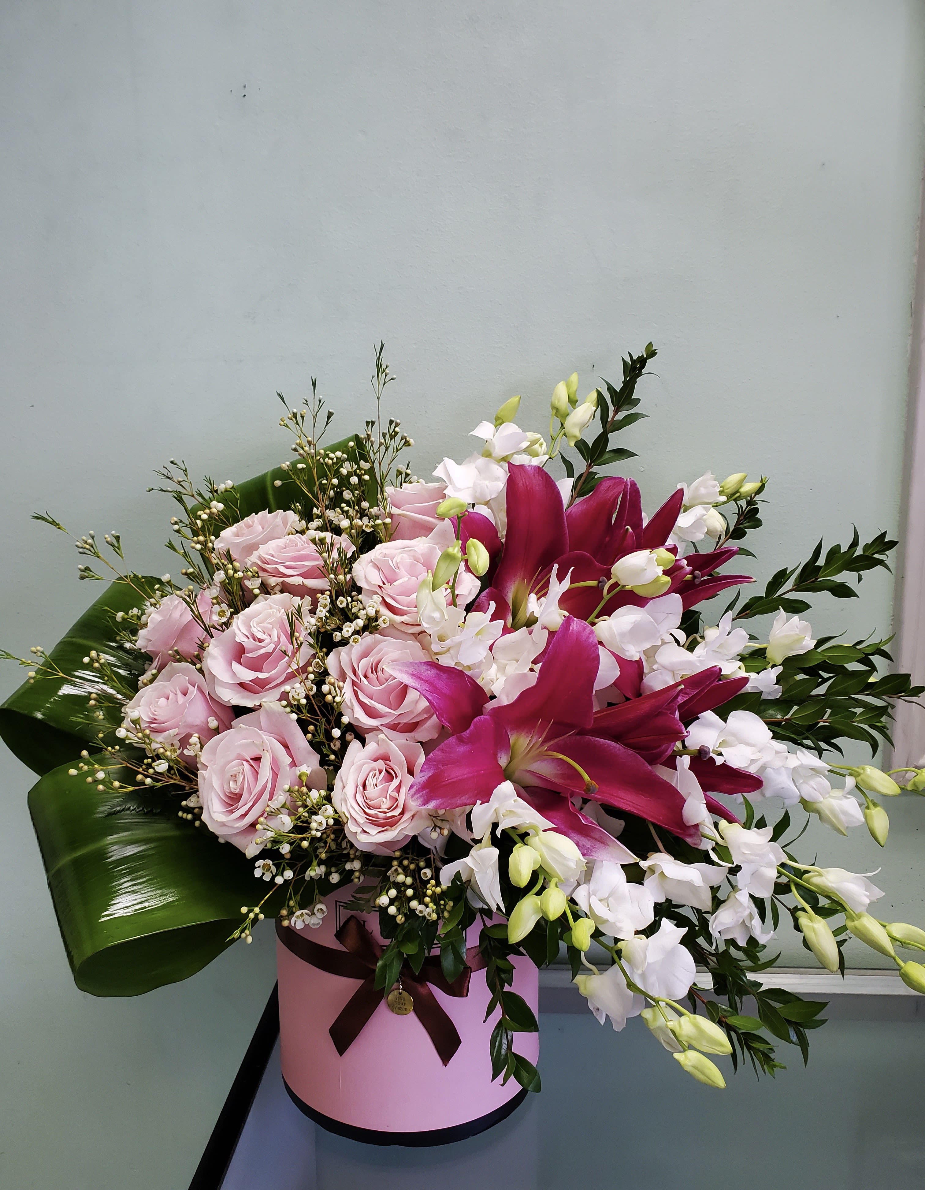 Blushing Beauty Blushing Beauty - Box arrangement with lilies, roses, and orchids.