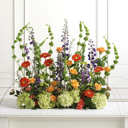 NATURES GIFT OF LOVE- STAGE OR PODIUM SPRAY NATURES GIFT OF LOVE- STAGE OR PODIUM SPRAY - A BEAUTIFUL GARDEN DISPLAY OF GREENS, PURPLES, ORANGES AND YELLOWS. FEATURING HYDRANGEA AND BELLS OF IRELAND.