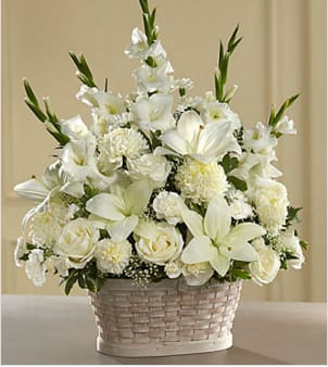 The Peaceful Passage Arrangement - Let this exquisite bouquet deliver your sincere condolences at this time of loss and sadness. An always-appropriate mixed bouquet of white roses, carnations, gladioli, football chrysanthemums, LA hybrid lilies, and million star gypsophelia plus an assortment of lush greens comes hand-arranged in a charming white wood chip basket by a local artisan florist. This versatile arrangement is perfect for display on a table, floor or pedestal at a funeral home, on an altar, floor or sanctuary steps for a funeral, and graveside at a burial ceremony. 