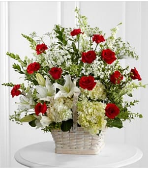 The In Loving Memory Arrangement - The In Loving Memory Arrangement pays tribute to a life well-lived with every beautiful bloom. Red roses and carnations pop amongst this incredible arrangement of white hydrangea, Oriental lilies, snapdragons, larkspur, Queen Anne's Lace and assorted lush greens, lovingly arranged in a large whitewash rectangular basket to create an impressive display of caring kindness. GOOD basket includes 29 stems. Approximately 28&quot;H x 28&quot;W. Your purchase includes a complimentary personalized gift message.