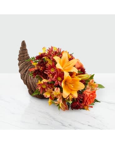 Harvest Comfort Cornucopia - Harvest Comfort Cornucopia shares every message of gratitude during Thanksgiving. A natural, woven cornucopia is filled to the brim with orange roses, Asiatic lilies, fall pompons and glycerized oak leaves. Make their day and delight their home with our stunning Autumn arrangement.