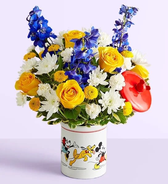 Disney Mickey Mouse &amp; Friends Cookie Jar- Baby Boy - EXCLUSIVE Welcome the little prince with a gift full of character(s)! Part of our new Disney collection, this handcrafted bouquet is gathered in happy yellow, blue and white blooms and designed in our whimsical Mickey Mouse and Friends cookie jar, featuring iconic animations. Great as a keepsake container or for keeping treats, it’s an adorable way to celebrate the littlest Disney fan and family