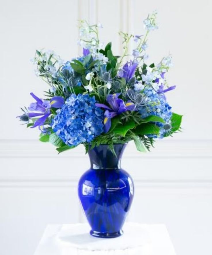 Frankly Speaking Frankly Speaking - A classic blue vase filled with blue hydrangea, delphinium, iris and thistle.