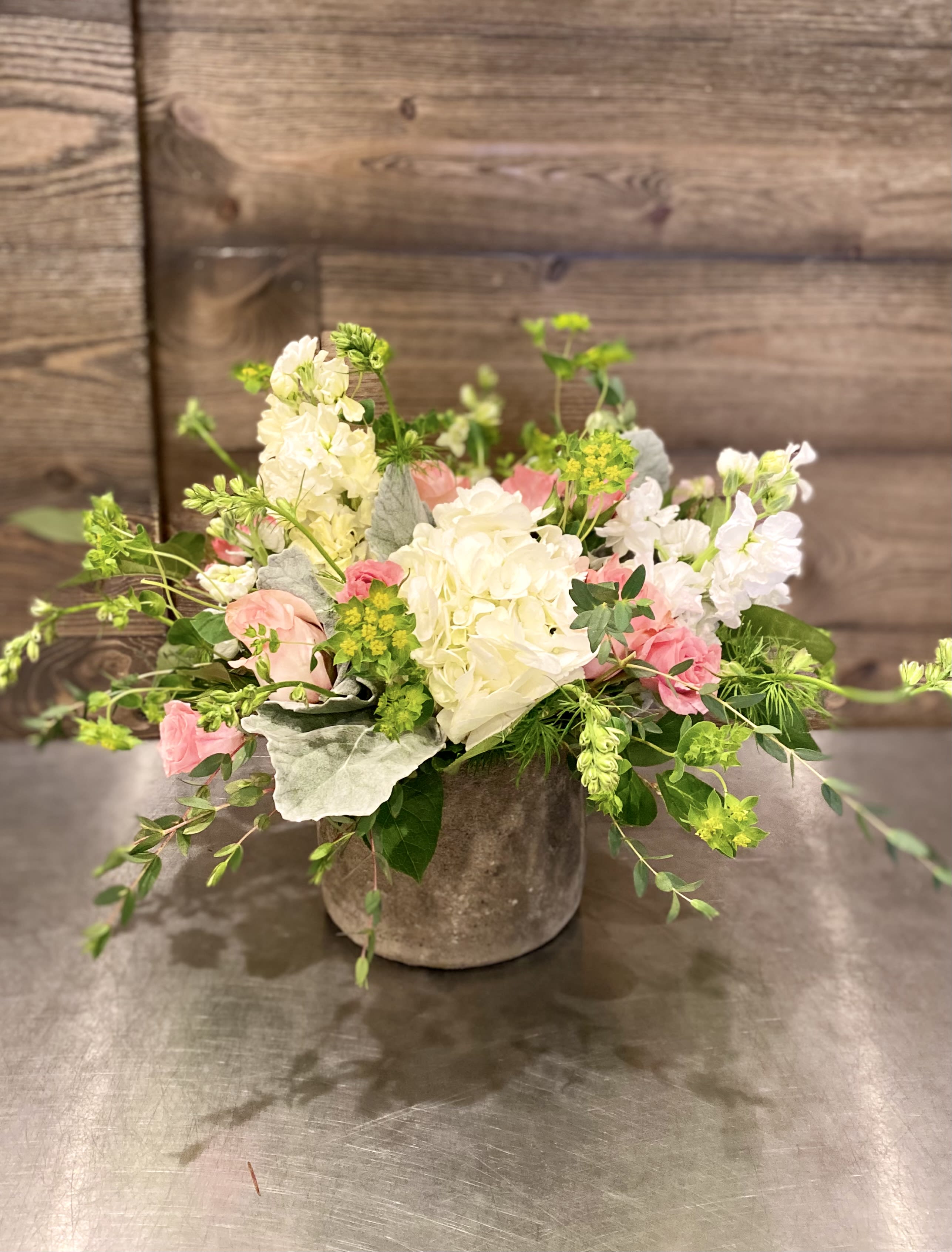 Bountiful Garden - Inspired by French country gardens, this captivating flower bouquet has a Victorian styling your recipient will adore. White and salmon roses made the eyes dance while surrounded by pink larkspur, peach spray roses, clouds of white hydrangea, dusty miller stems, and lush greens,