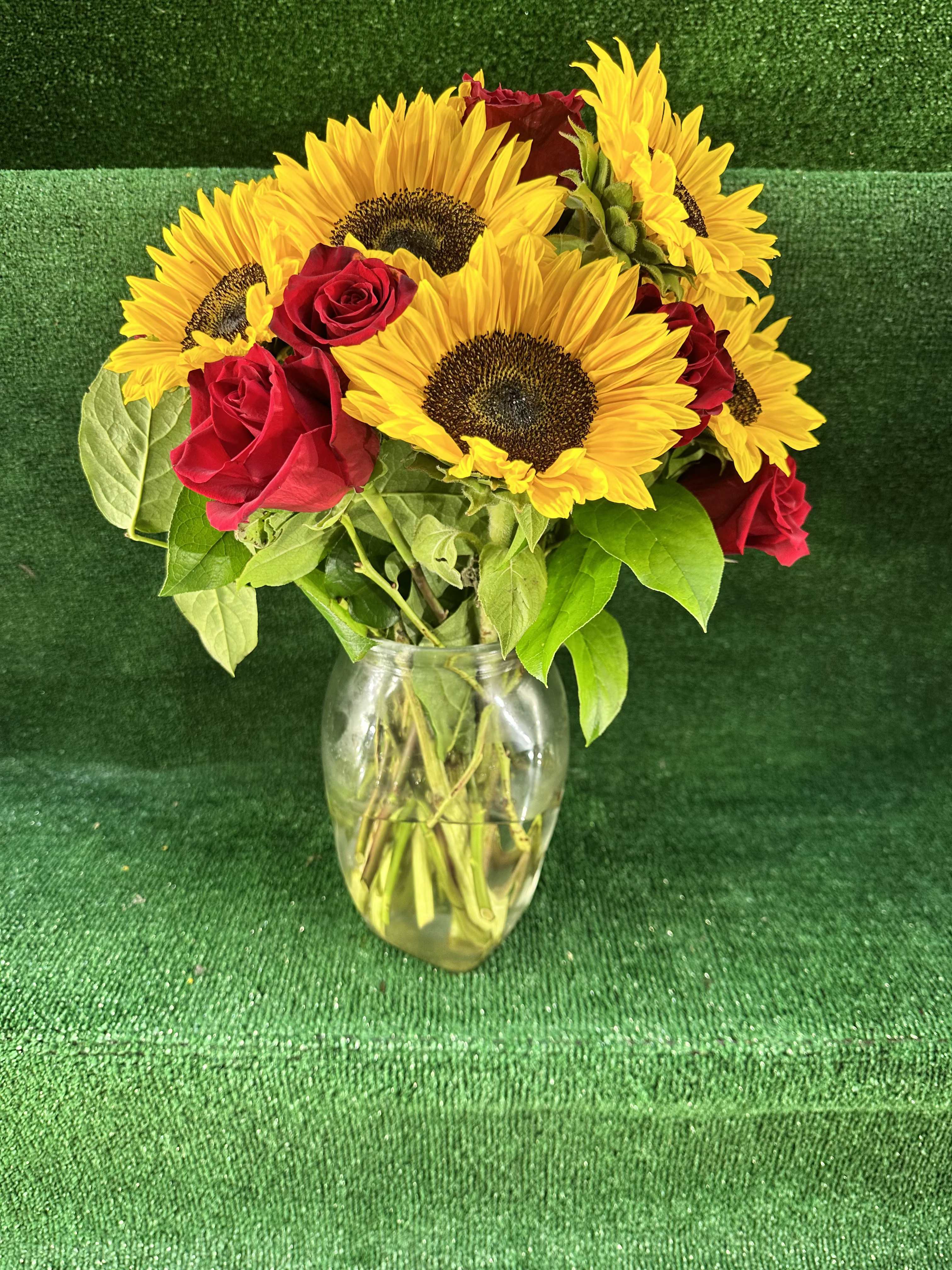 Red Roses &amp; Sunflowers in a Vase - Bring warmth and romance into any space with our Red Roses &amp; Sunflowers in a Vase. This stunning arrangement combines the passionate beauty of vibrant red roses with the cheerful, golden glow of sunflowers. Arranged in a stylish vase, it’s a perfect balance of love and happiness.  Ideal for anniversaries, birthdays, or just because, this bouquet is sure to brighten any room and any heart.