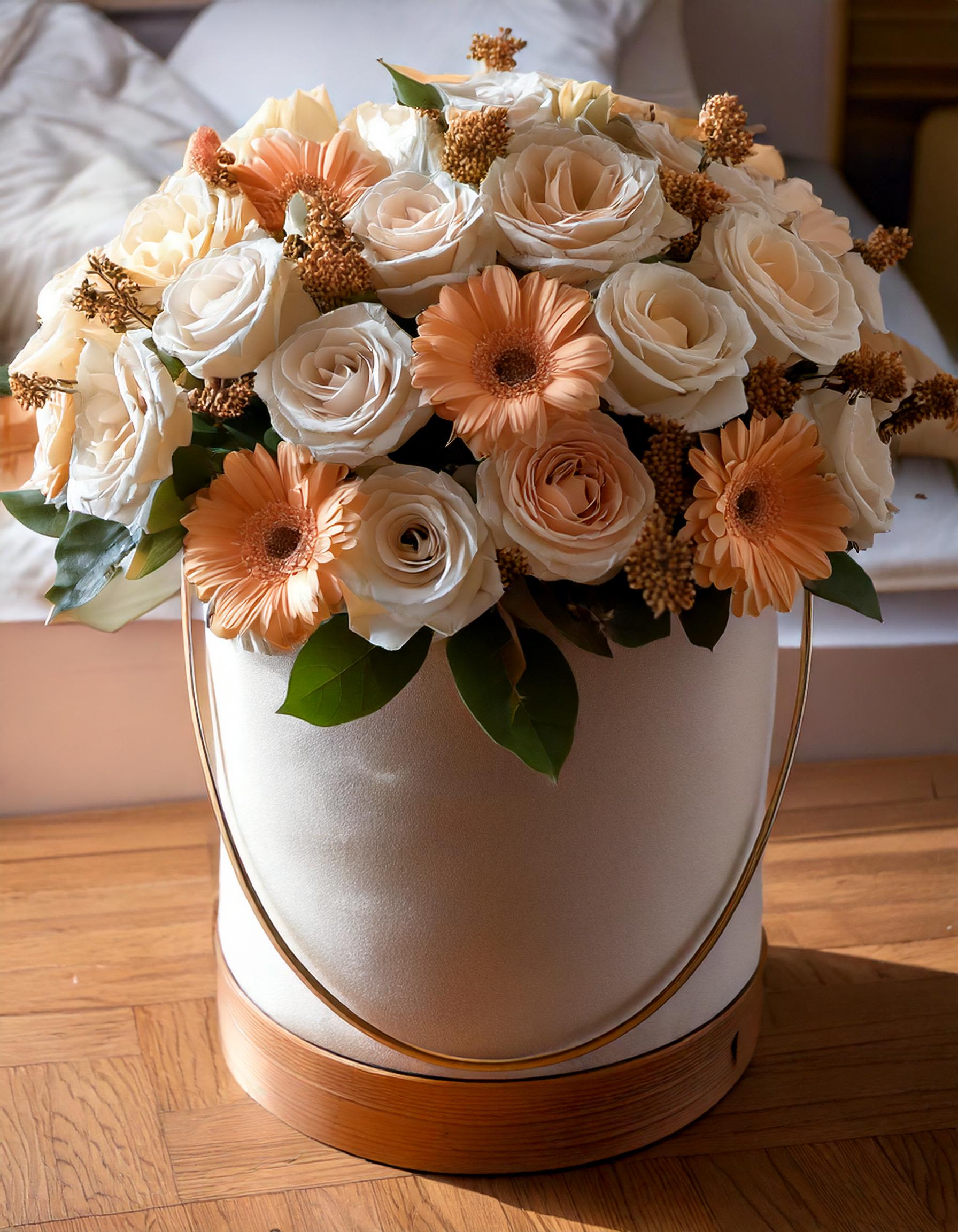 Moonlight - This elegant arrangement, featuring soft ivory roses, peach gerberas, and textured accents, is perfect for creating a warm and sophisticated atmosphere. The blooms are beautifully presented in a luxurious hatbox, making it an ideal choice for a romantic gift, anniversary, or a birthday surprise