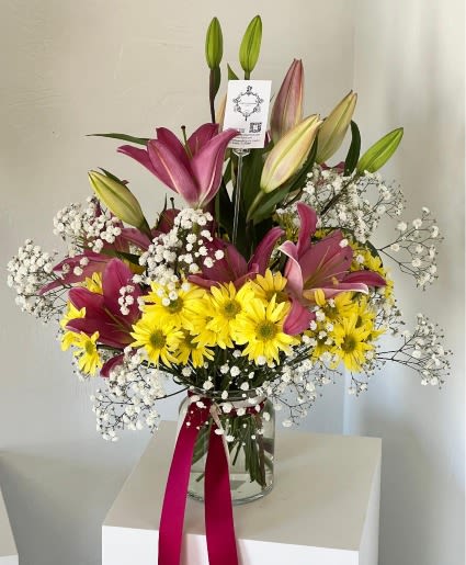 Made You Smile - The name says it all! Turn any frown upside down with this cheerful assortment of lilies, daisies, and baby’s breath all tied up with a ribbon. 