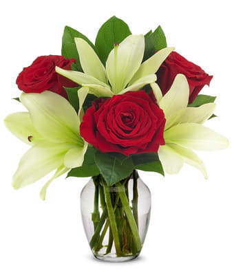Loving Lilies and Roses Loving Lilies and Roses - This elegant arrangement will enhance your evening celebrating. The Red Roses and White Lilies accented with seasonal greenery arranged in a clear glass vase will enhance your décor.