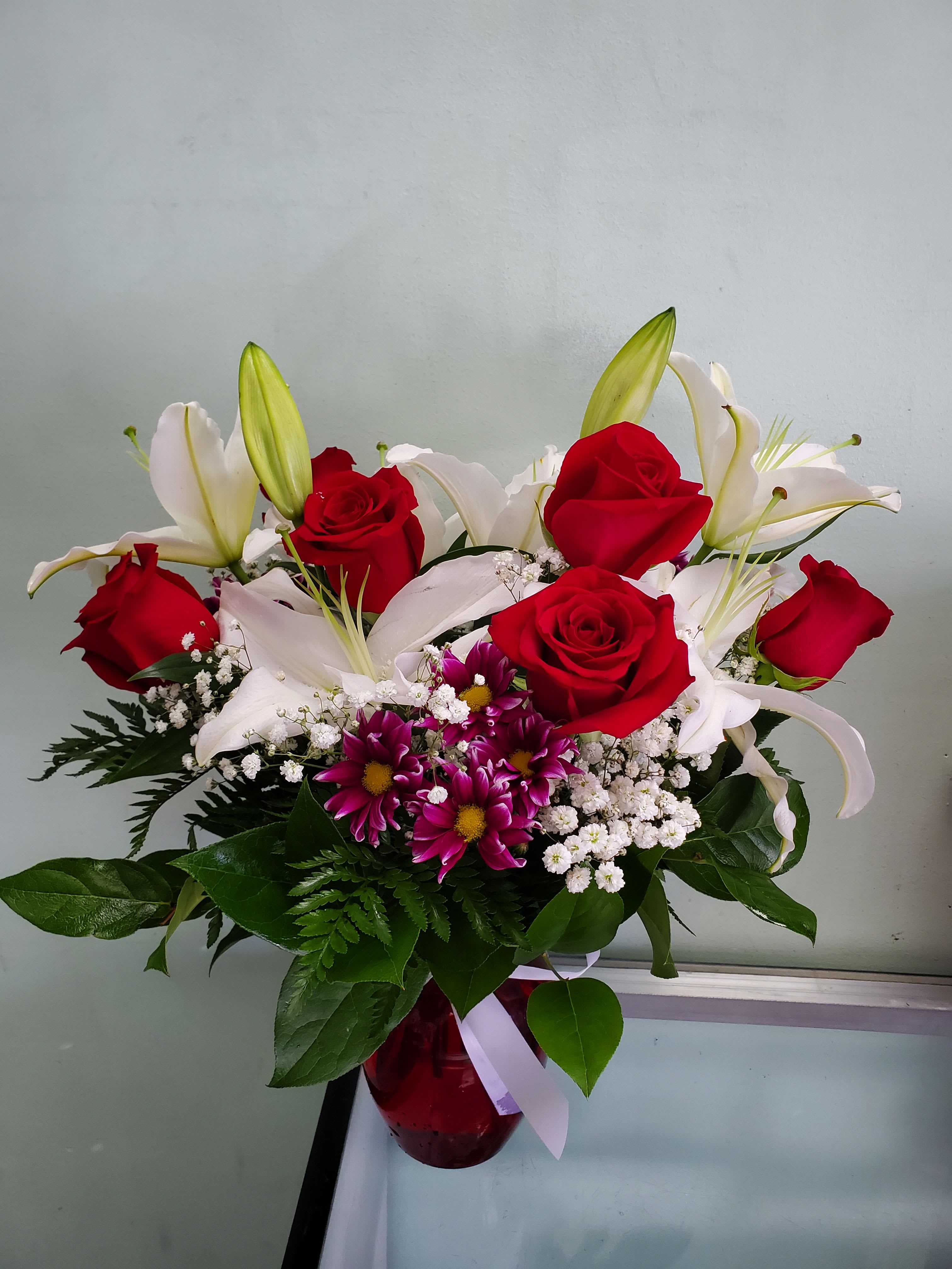 Love Patch Love Patch - Vase arrangement with roses, daisies, and lilies.