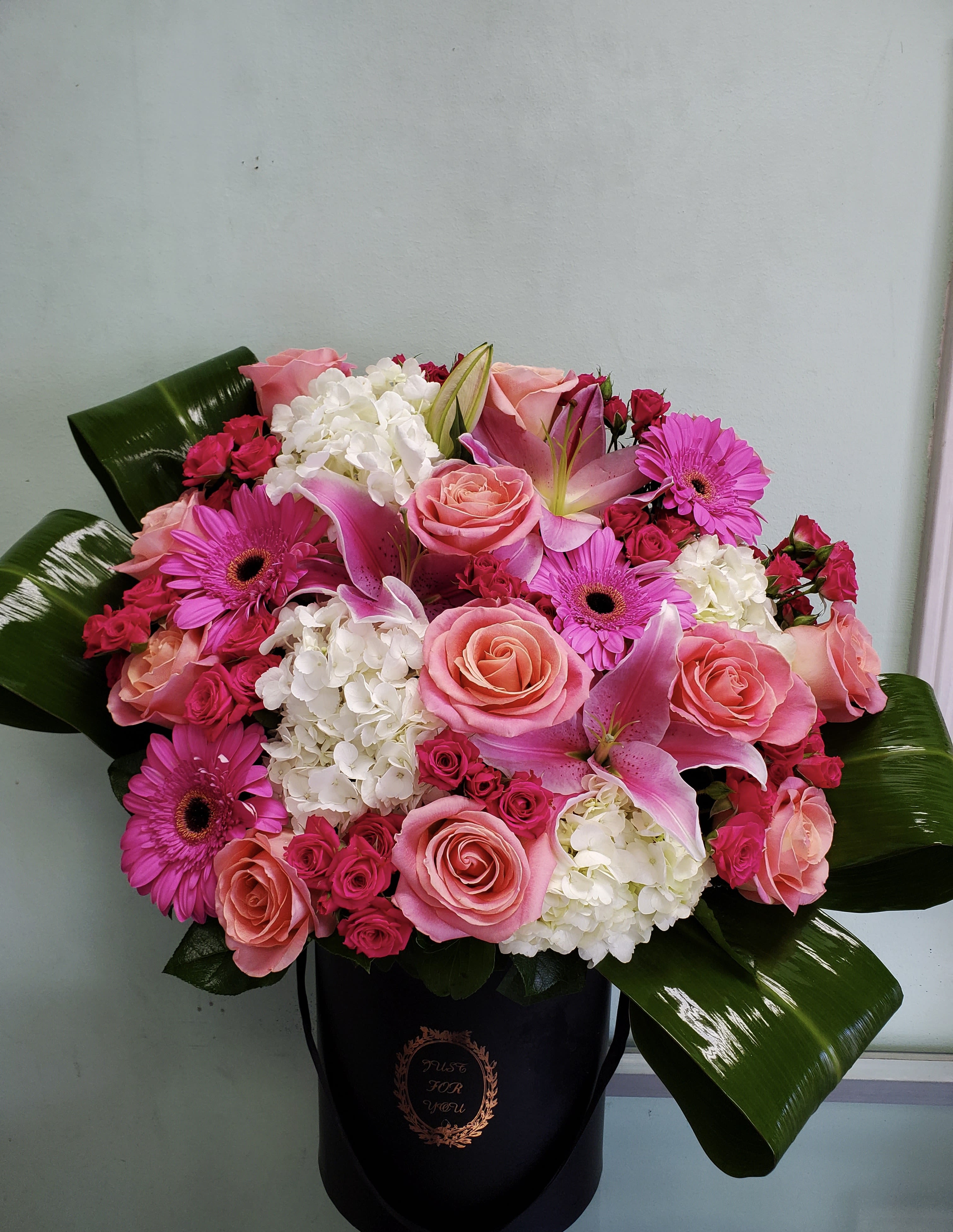Pink Story  - Box arrangement with gerbera daisies, lilies, roses, spray roses, and hydrangeas. 