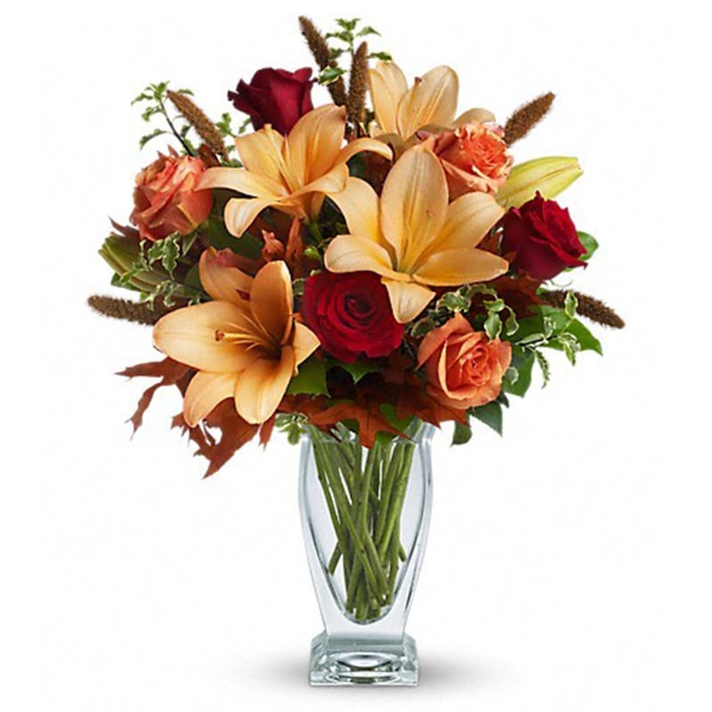 Fall Fantasia [T167-1A] - Absolutely exquisite! This bouquet is a fall flower fantasy come true. All the richness of this colorful season is captured in a stylish glass vase. So pretty, you might have to order one for a friend and one for yourself!  Beautiful orange and red roses, yellow asiatic lilies, autumn oak leaves and more are beautifully arranged in an exclusive Couture Vase. Isn't fall fantastic?  Approximately 17&quot; W x 20&quot; H  Orientation: One-Sided      As Shown : T167-1A