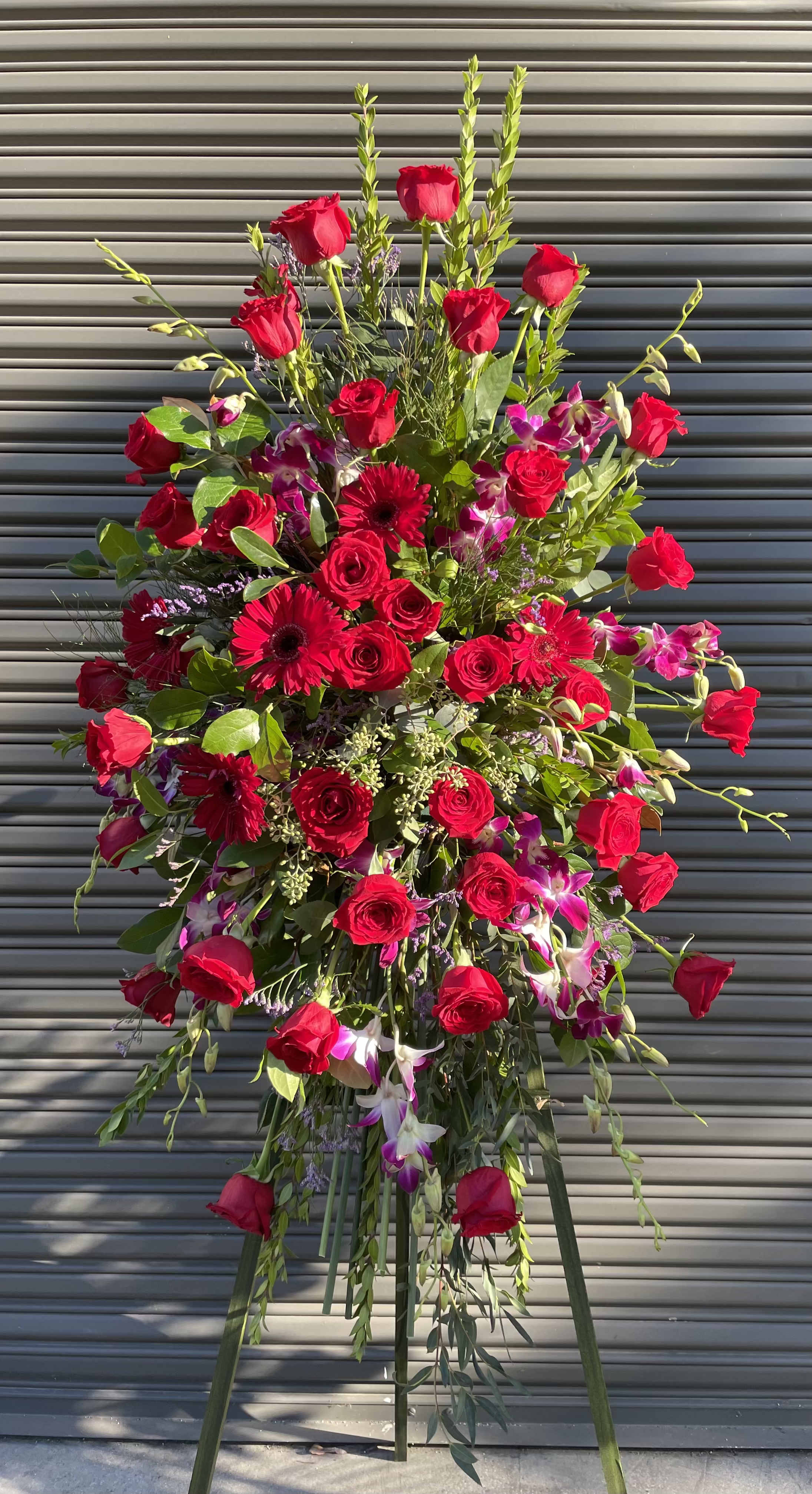 Red and Purple Spray - This standing spray includes roses, dendrobium orchis
