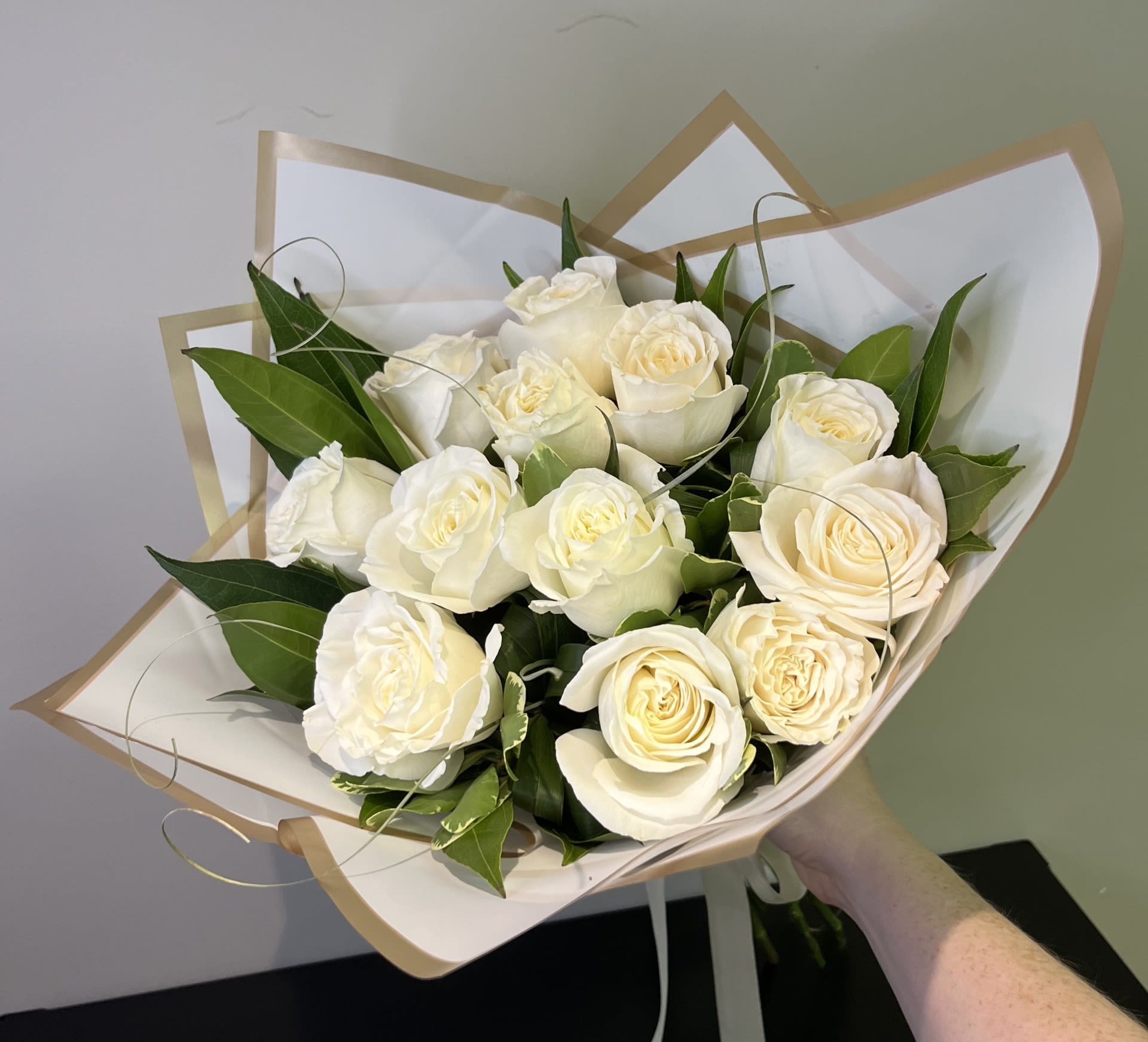 White Rose Handtied Bouquet by Chasing Petals - White roses arranged with elegant greenery.
