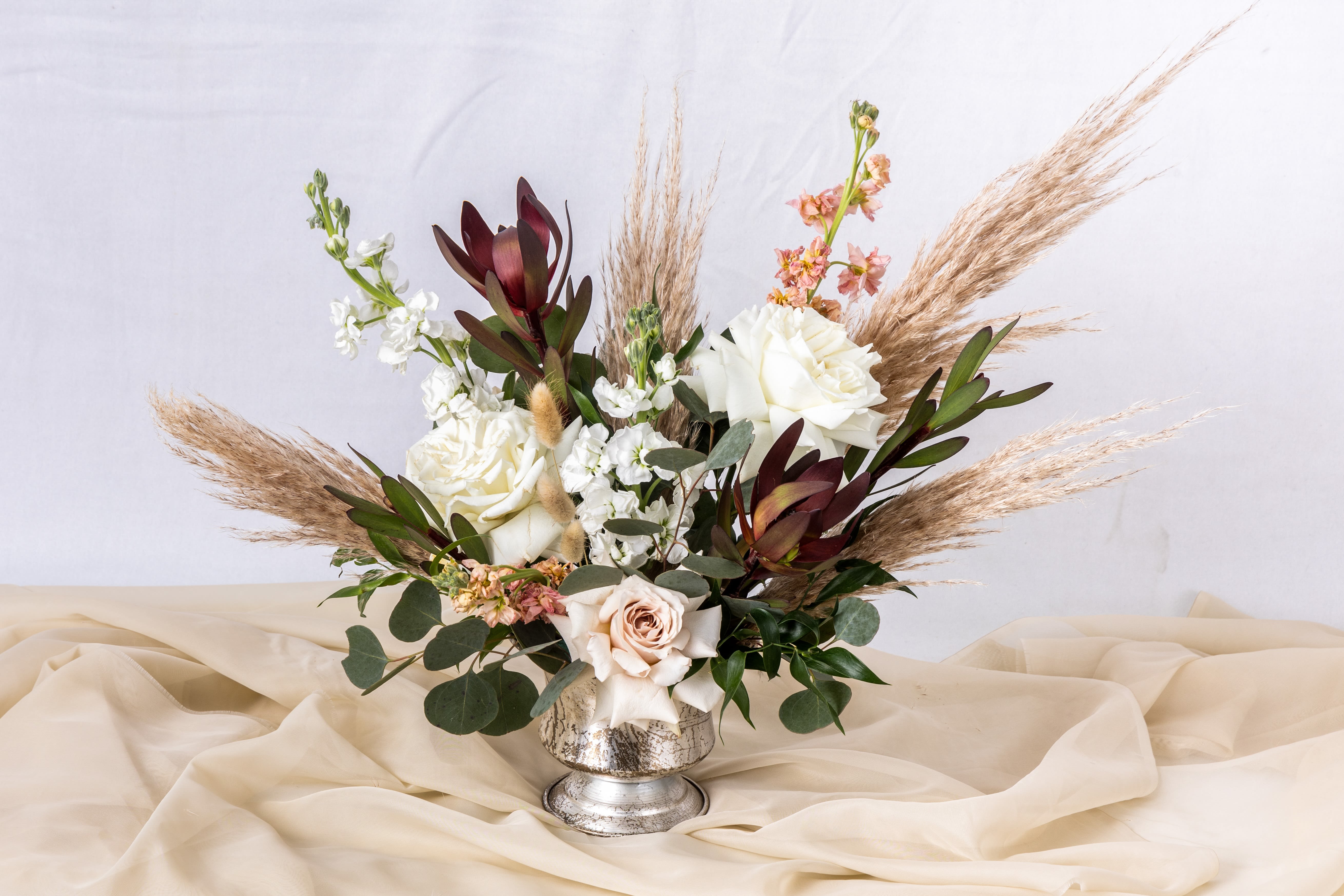 Boho Bliss - Boho and cream floral arrangements exude natural charm and understated elegance. Featuring soft cream tones paired with earthy textures, wild greenery, and rustic accents, these designs create a free-spirited and organic vibe. Perfect for bohemian weddings, cozy celebrations, or effortlessly stylish decor, this combination embodies warmth, simplicity, and timeless beauty.