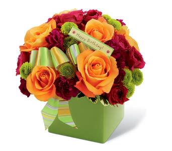 FESTIVE BIRTHDAY BOUQUET IN GREEN CERAMIC CONTAINER - The Festive Birthday Bouquet in Green Ceramic Cube by Twin Towers Florist is a bright splash of birthday fun that will add that little extra something to their big day! Orange roses are simply lovely arranged amongst fuchsia spray roses, plum miniature carnations and green button poms, accented with a lime green designer ribbon. Seated in a bright green ceramic block vase, this bouquet expresses your most happy wishes for a fantastic birthday.      As Shown : TT-BDYd 