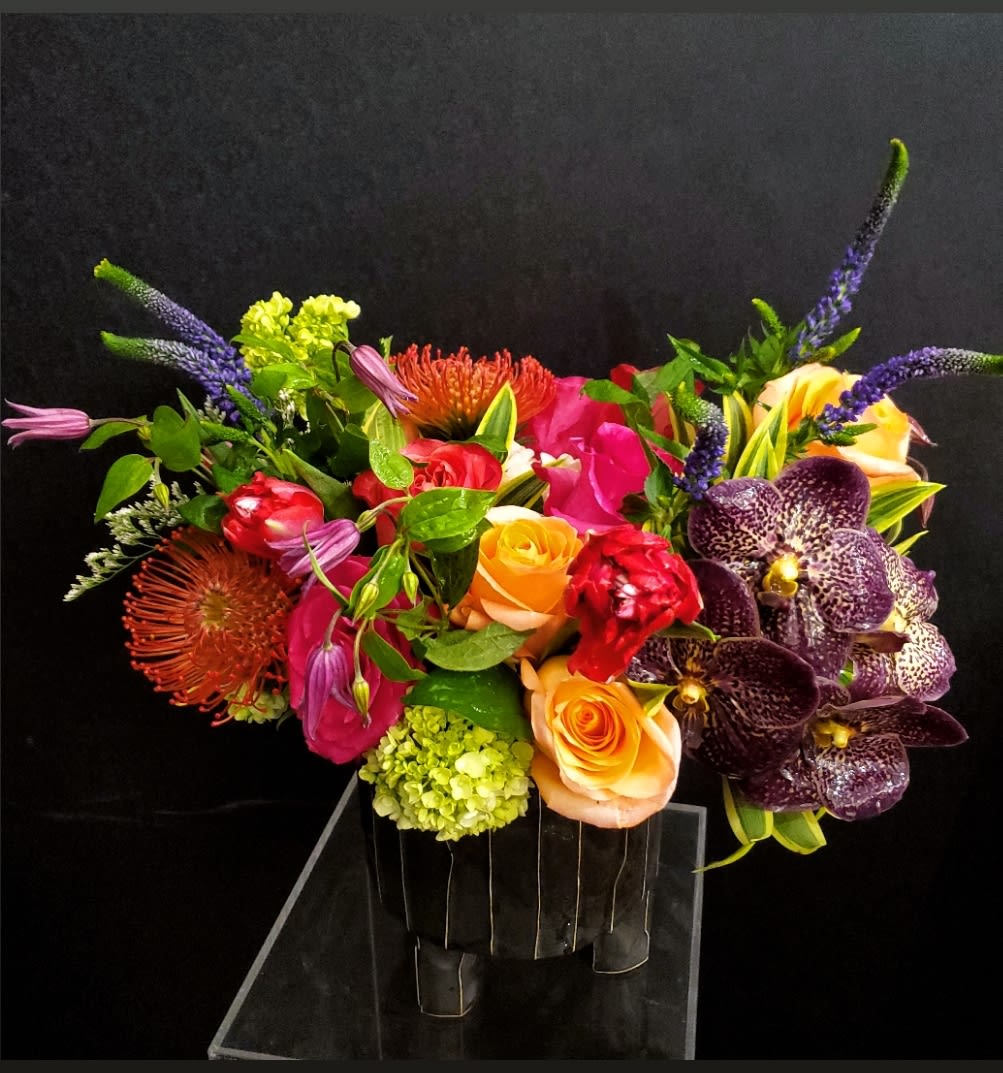 Sweet Tea and Turnip Greens Sweet Tea and Turnip Greens - Southern, sweet, sassy, andgGood for the soul! I can't think of any better words to describe this Bold Beauty designed in an architectural and stylish vessel! You will be "giver of the best southern bouquet ever" with this HIT of a southern classic! Includes all the goodies - Hydrangea, Vanda Orchids, Tulips, Garden Roses, Protea and more!