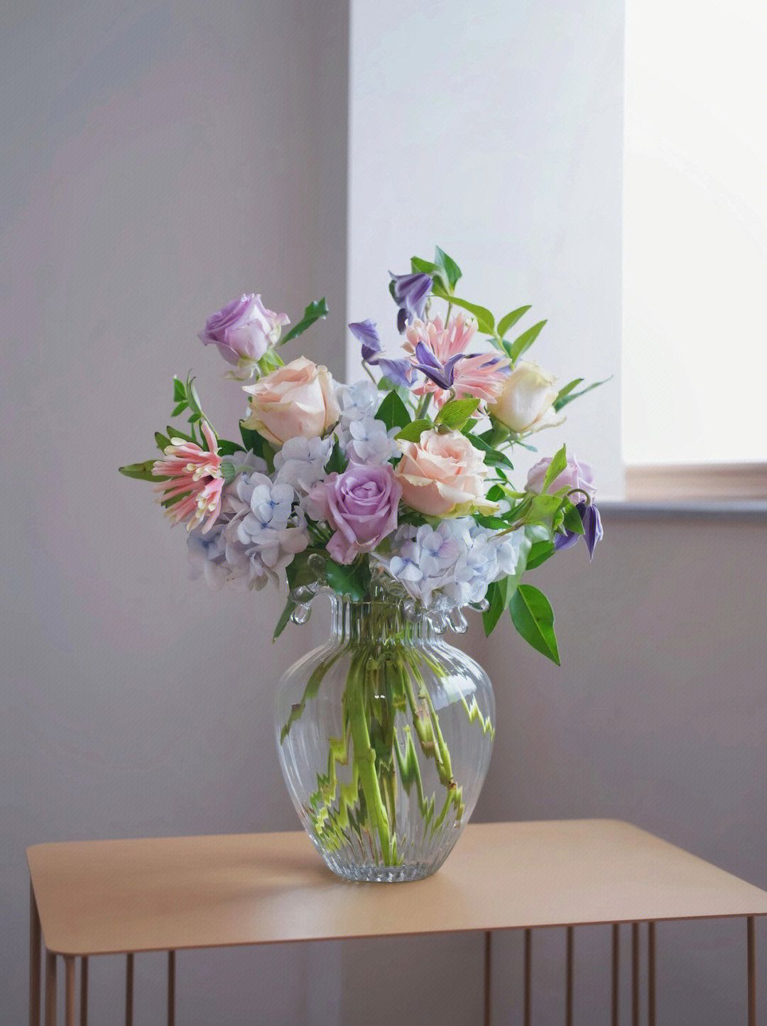 fresh - This is a mixed flower arrangement product, including roses, hydrangea, clematis and some green leaves, packed in a transparent glass container