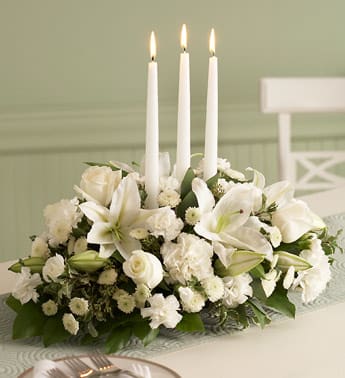 Formal Dinner Centerpiece with or without Candles Formal Dinner Centerpiece with or without Candles - They expect the flowers so why not send them a memory? Our oblong centerpieces come with a lush assortment of white flowers and holiday greenery. Please be sure to let us know is the "Special Instructions" section of your order if you do or do not want candles.