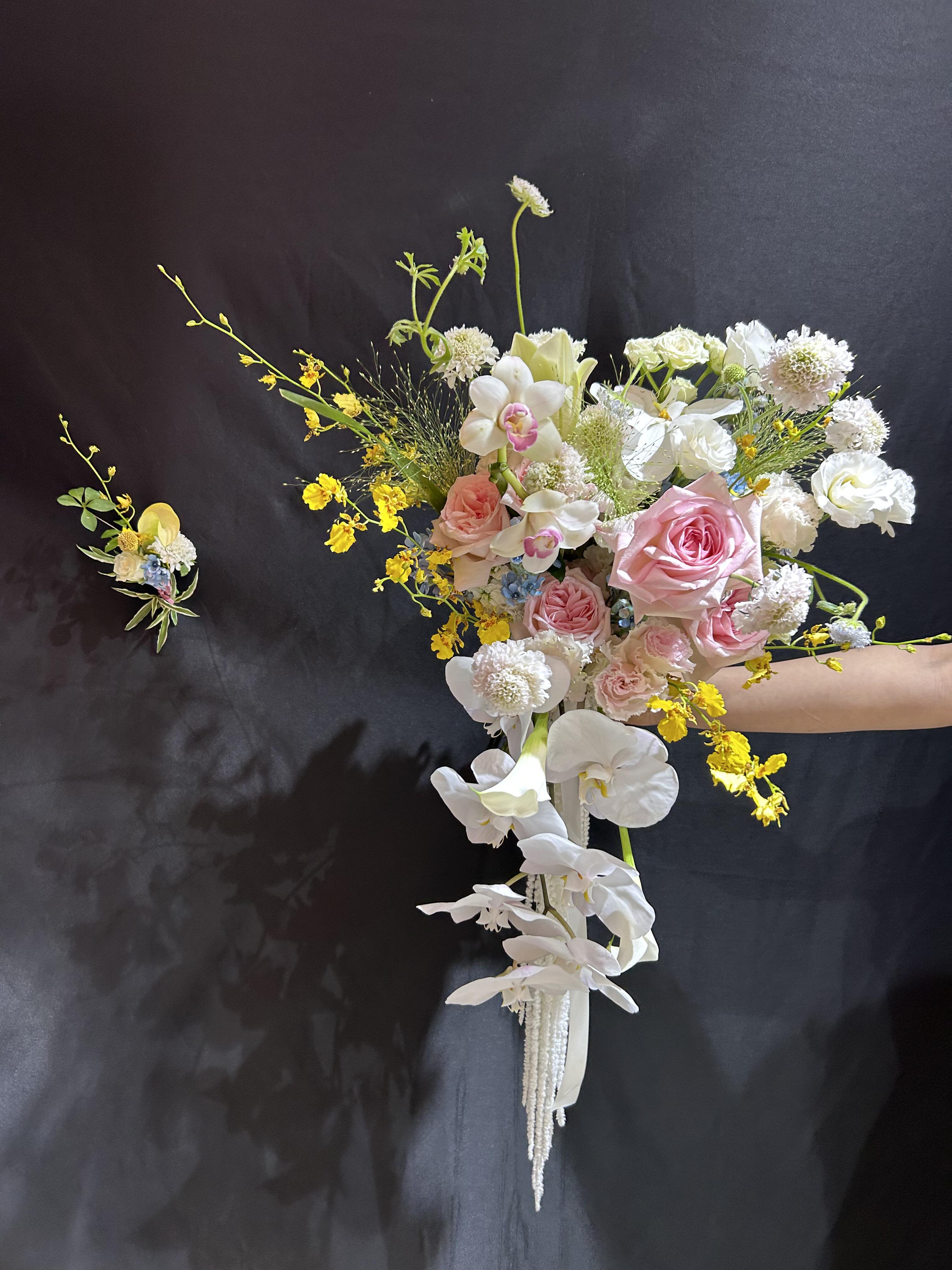 elegantly blooming cascade - Product contains rose, lisianthus, phalaenopsis, dahlia, green leaves stuffed and tied with ribbon