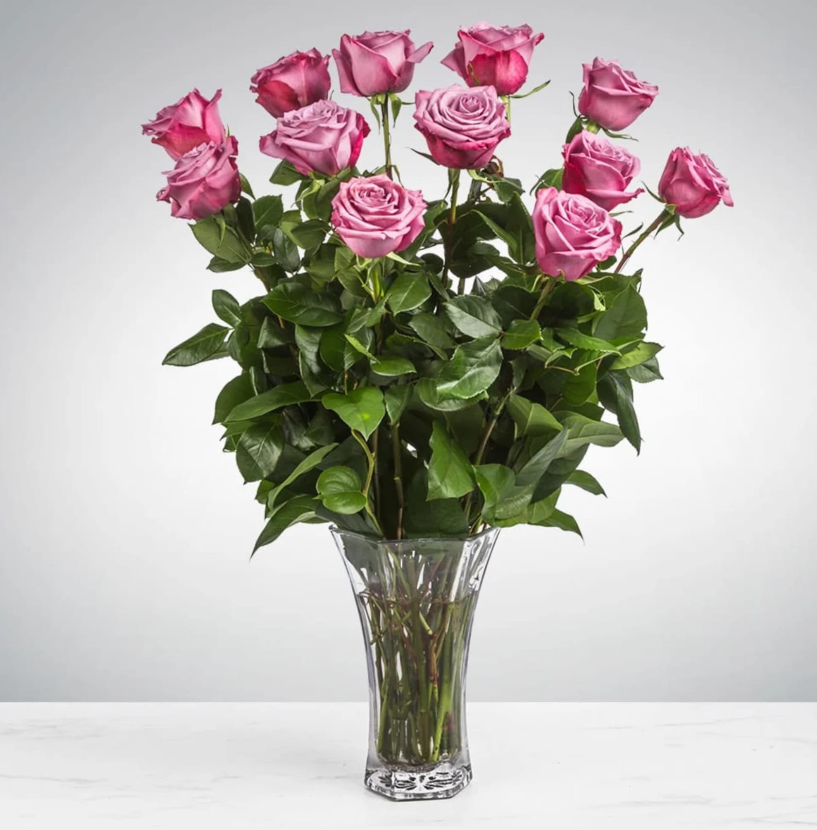 Dozen Long Stemmed Lavender Roses - This arrangement is the perfect &quot;pick me up&quot; to brighten someone's day. Dozen Long Stemmed Lavender Roses is the perfect gift for a birthday, get well, just because, and thank you.    Arrangement Details: 12 Long Stemmed Lavender Roses and Assorted Greenery APPROXIMATE DIMENSIONS: 25&quot; H X 18&quot; W