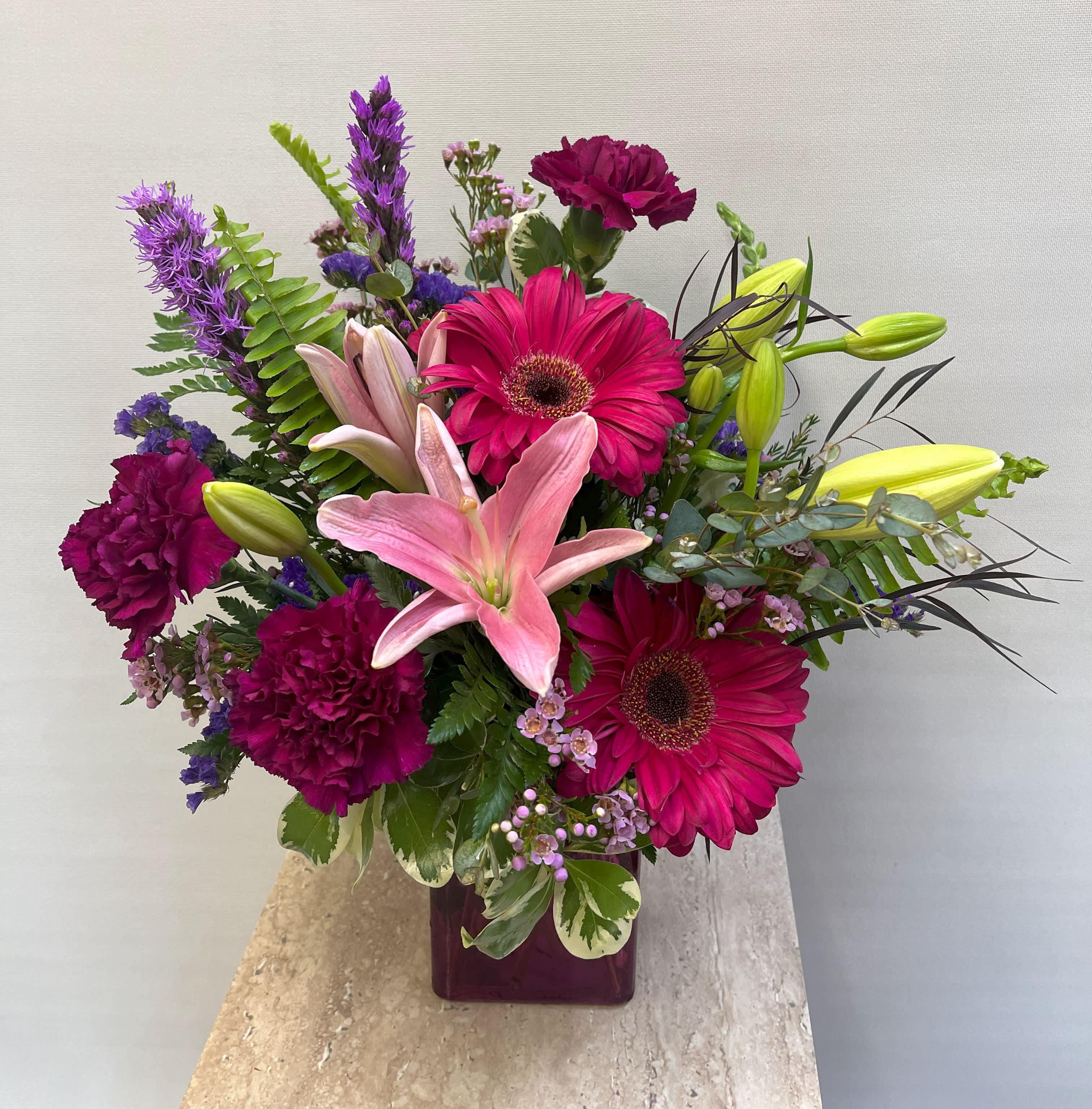 Purple Haze - Purple vase with a variety of purple and hot pink flowers.  Perfect for any occasion and guarantee to put a smile on someone's face. 